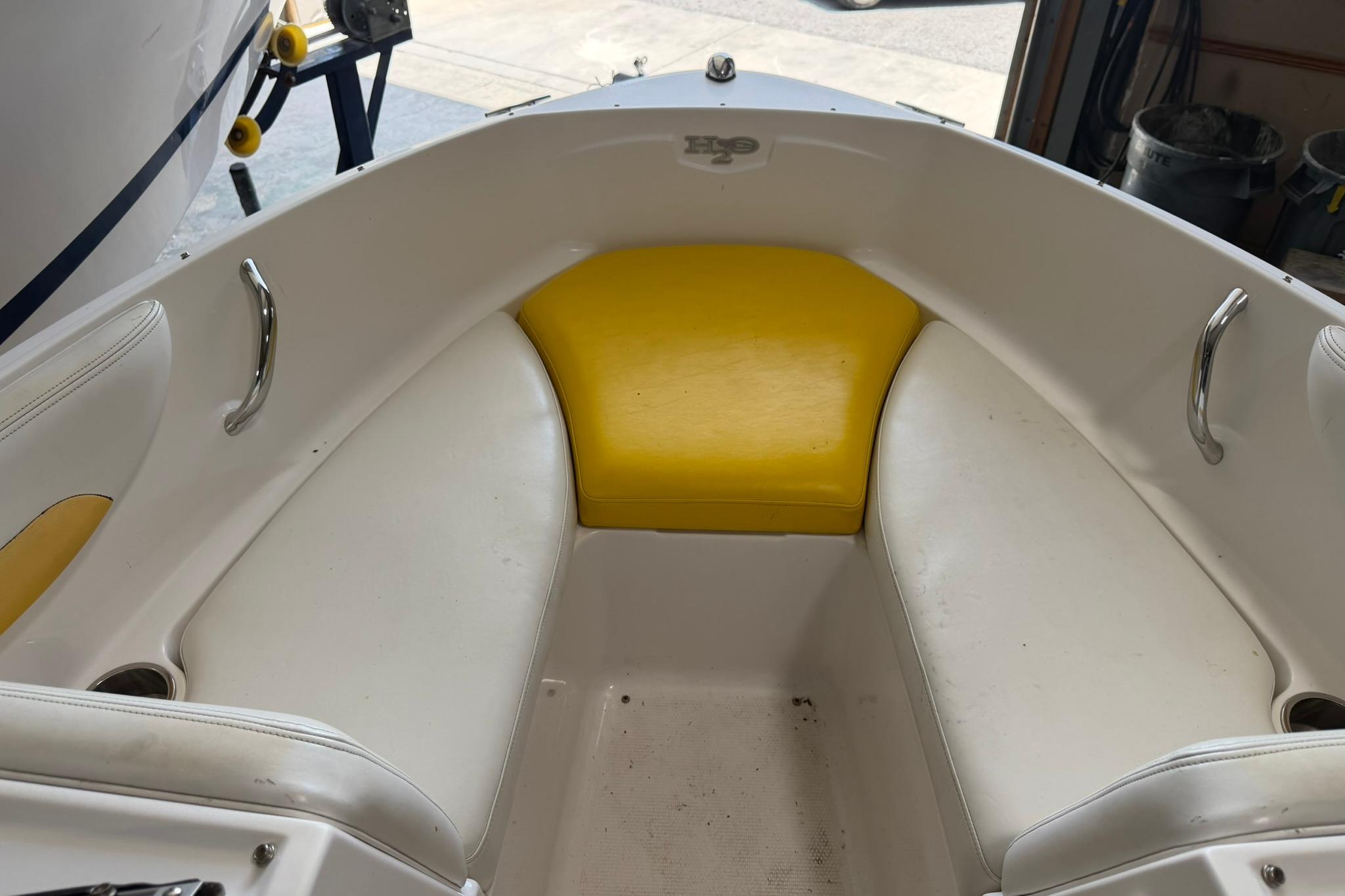 Interior of 2012 Chaparral 19 Sport H2O boat with white and yellow seating.