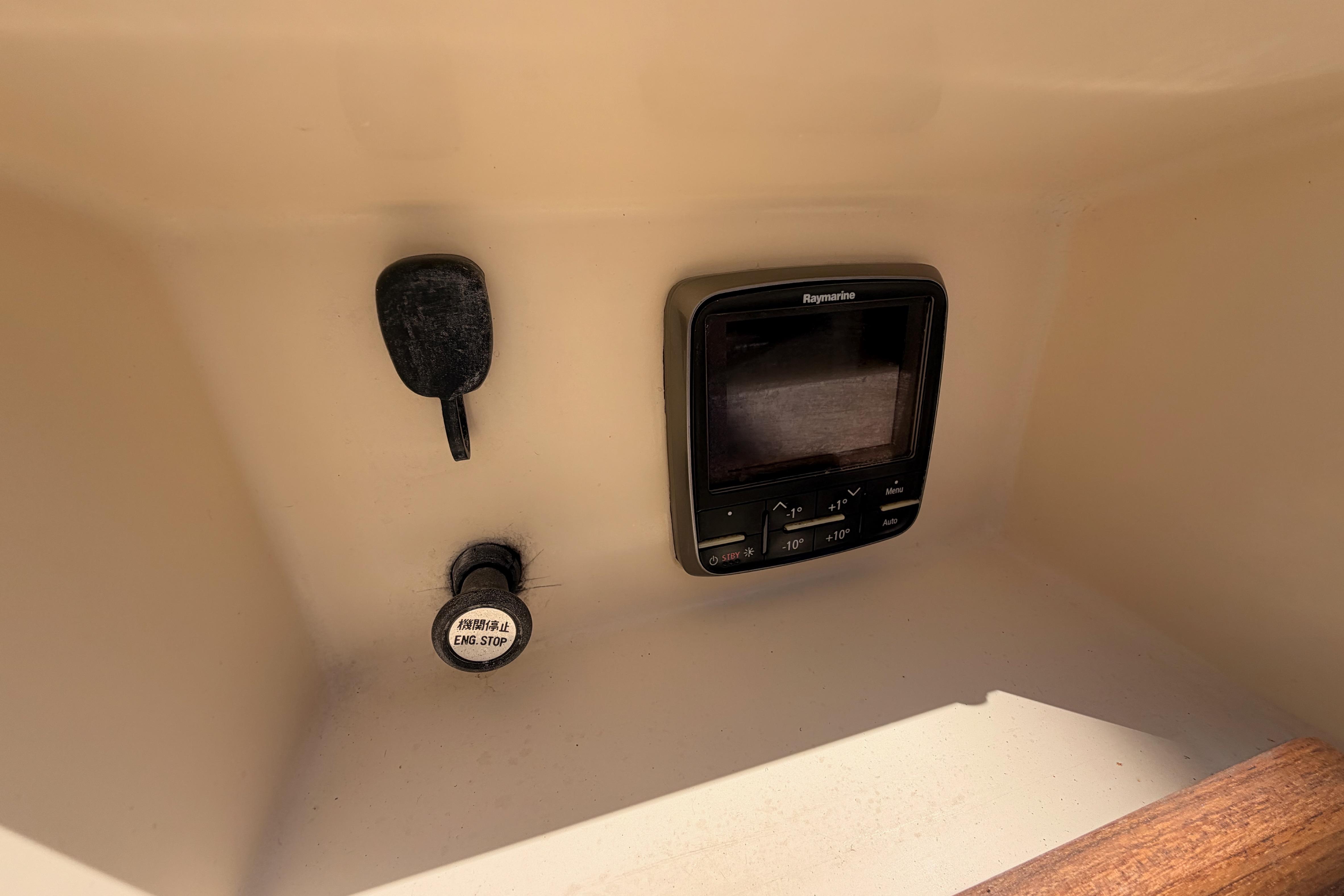 1991 Caliber 33 boat dashboard with Raymarine display and engine stop button.