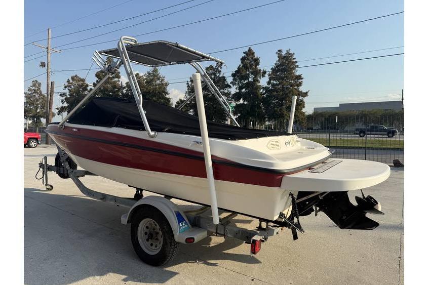 2008 Bayliner 185 Bowrider on trailer, red and white, with canopy and cover.