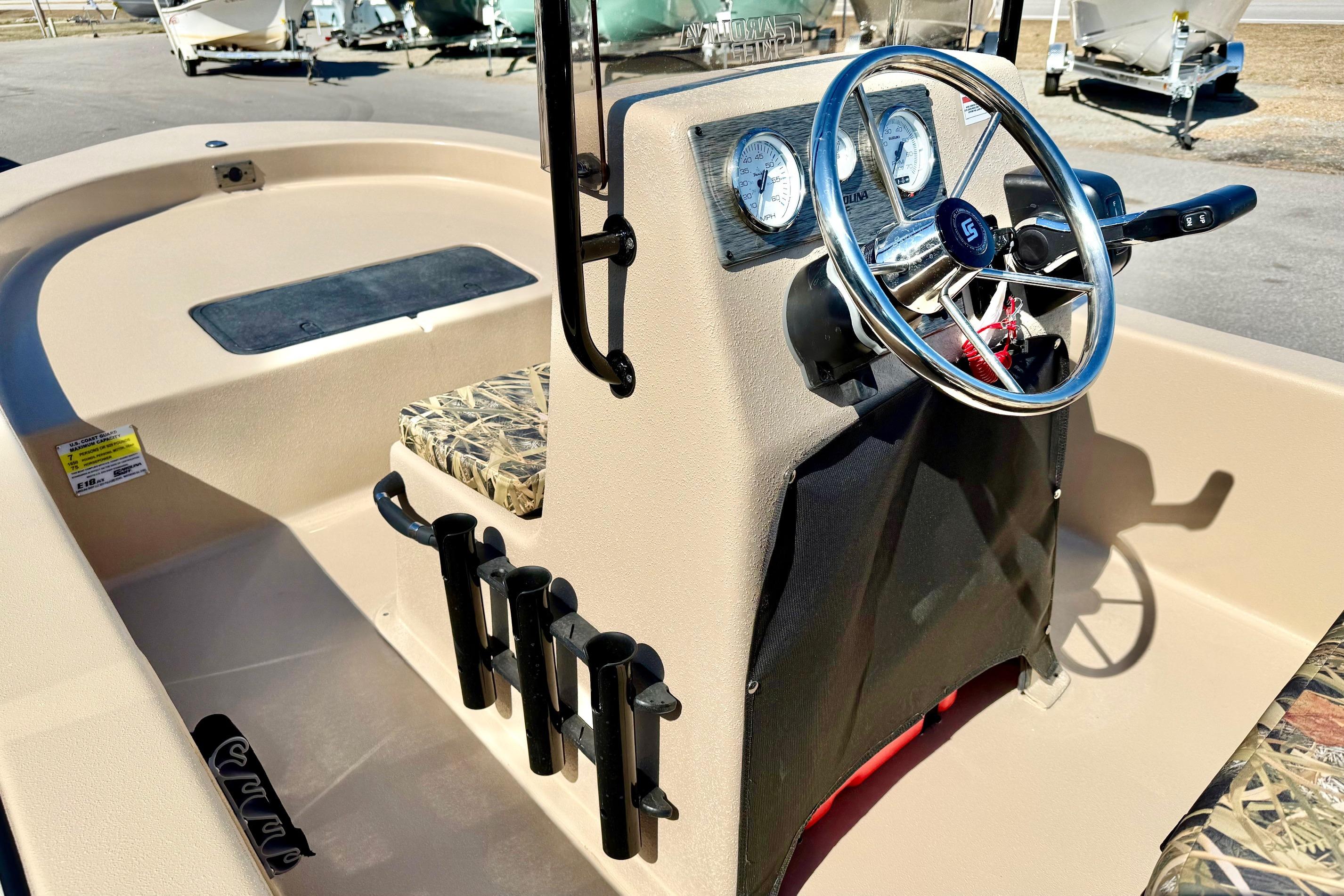 2026 Carolina Skiff E18 JVX CC boat interior with steering wheel and camo seating.