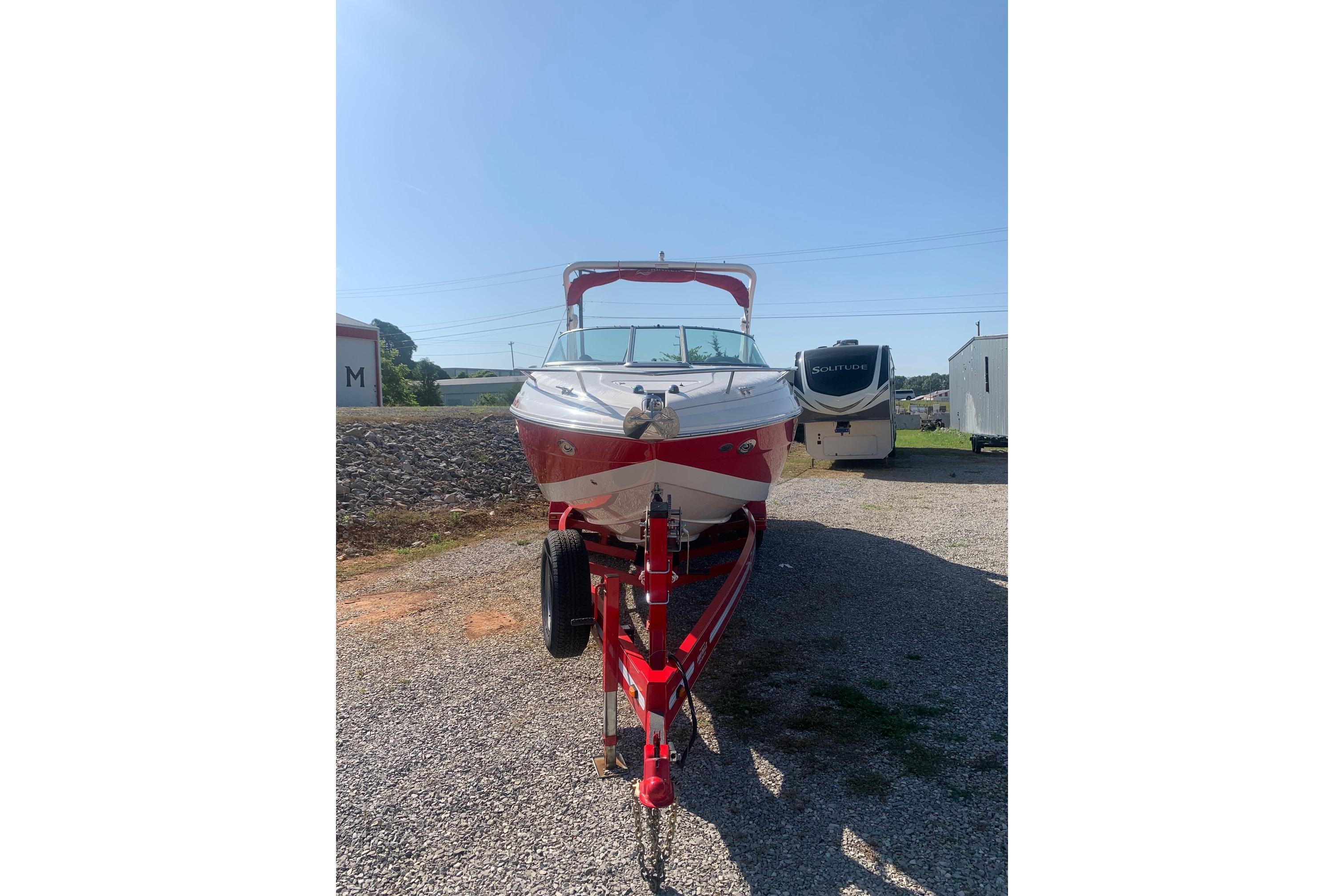 2006 Rinker 282 Captiva Cuddy boat on trailer, parked outdoors.