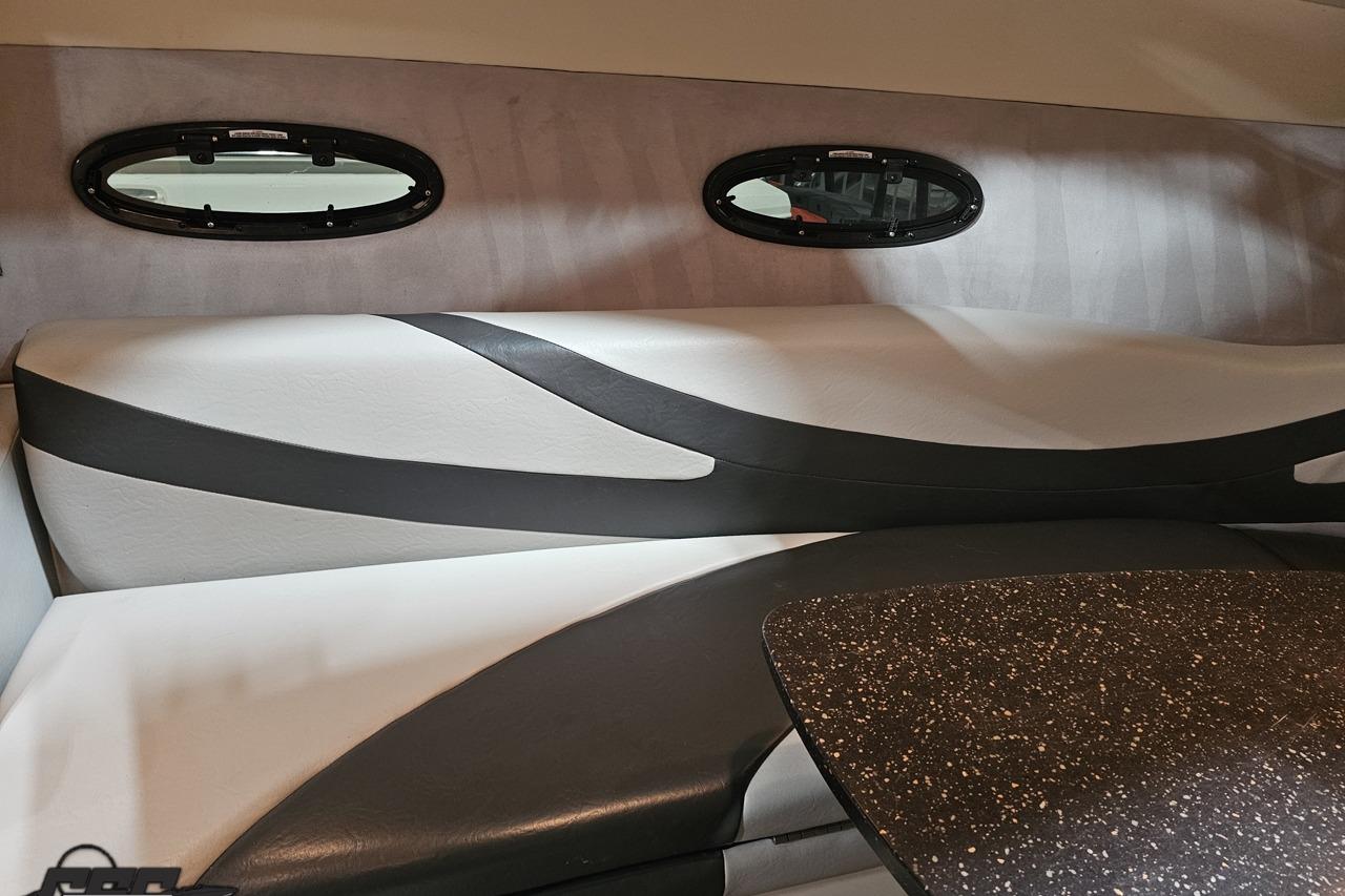 Interior of a 2008 Baja 335 Performance boat, featuring sleek seating and oval windows.