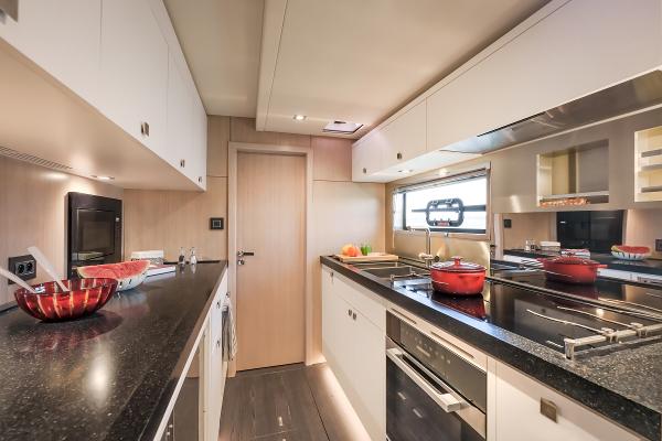 Modern kitchen interior on Privilege Signature 650 yacht, 2025 model, featuring sleek countertops and appliances.
