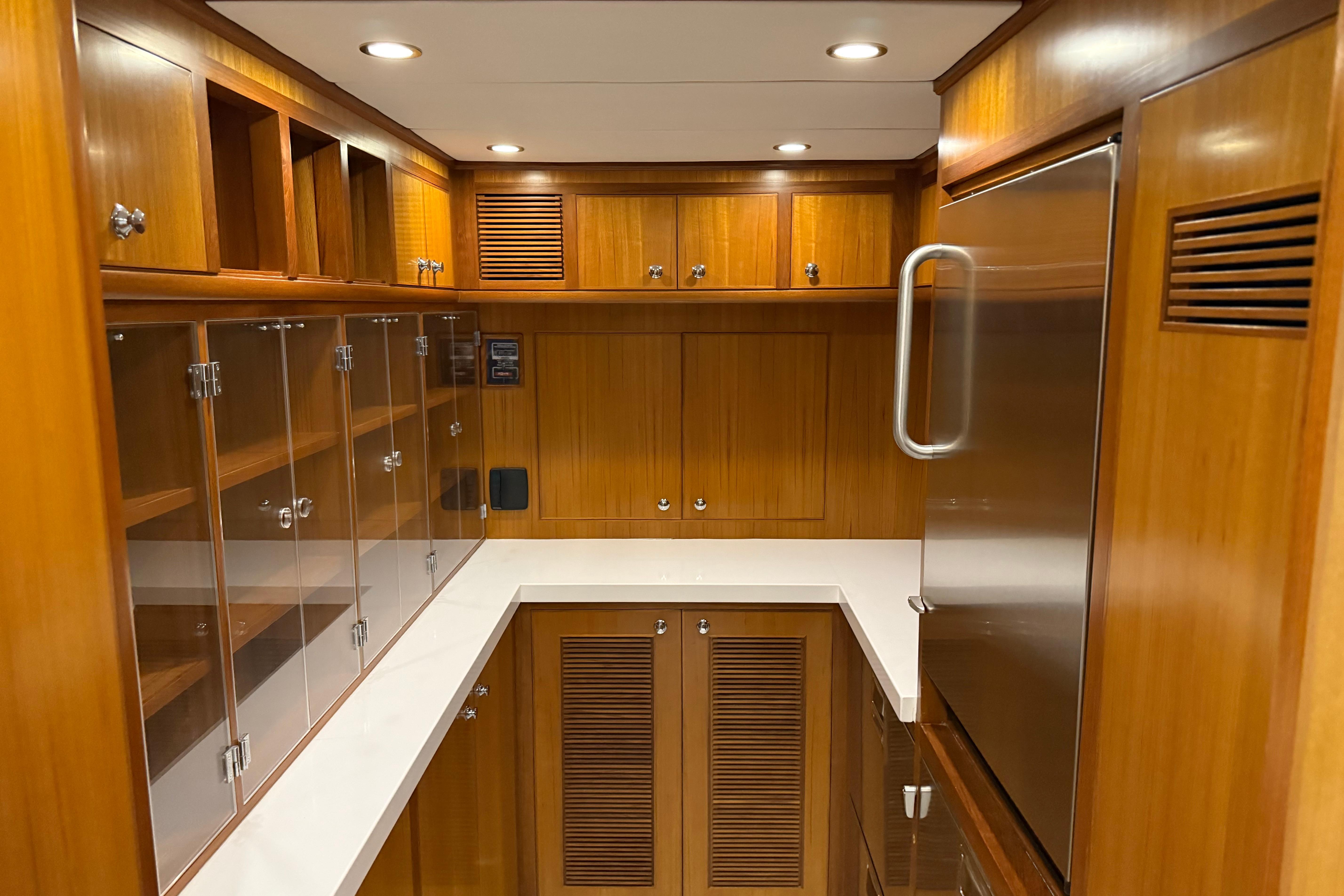 Luxurious wooden interior of 2009 Nordhavn N64 yacht kitchen with modern cabinetry.