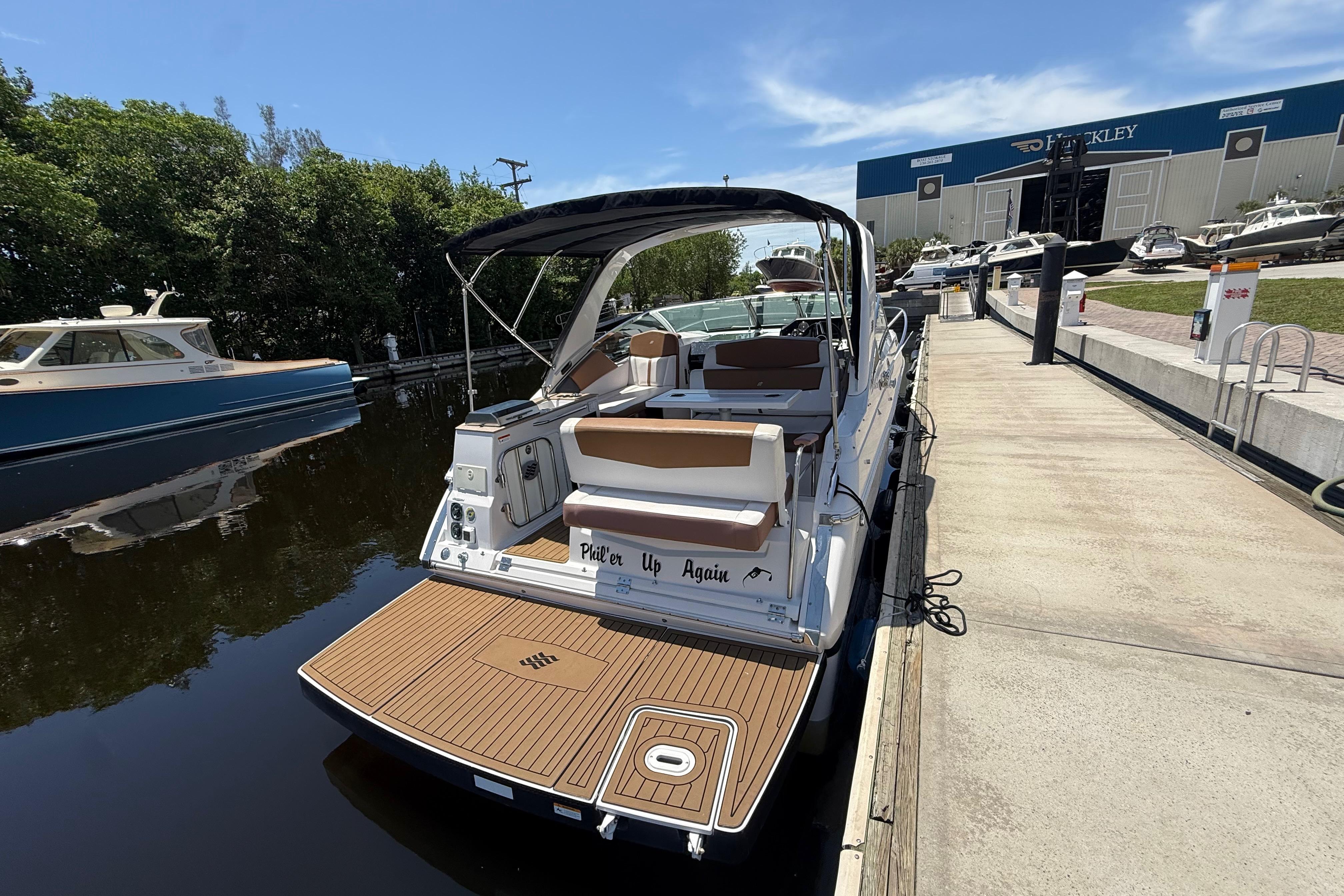2017 Four Winns V275 boat docked at marina with scenic background.