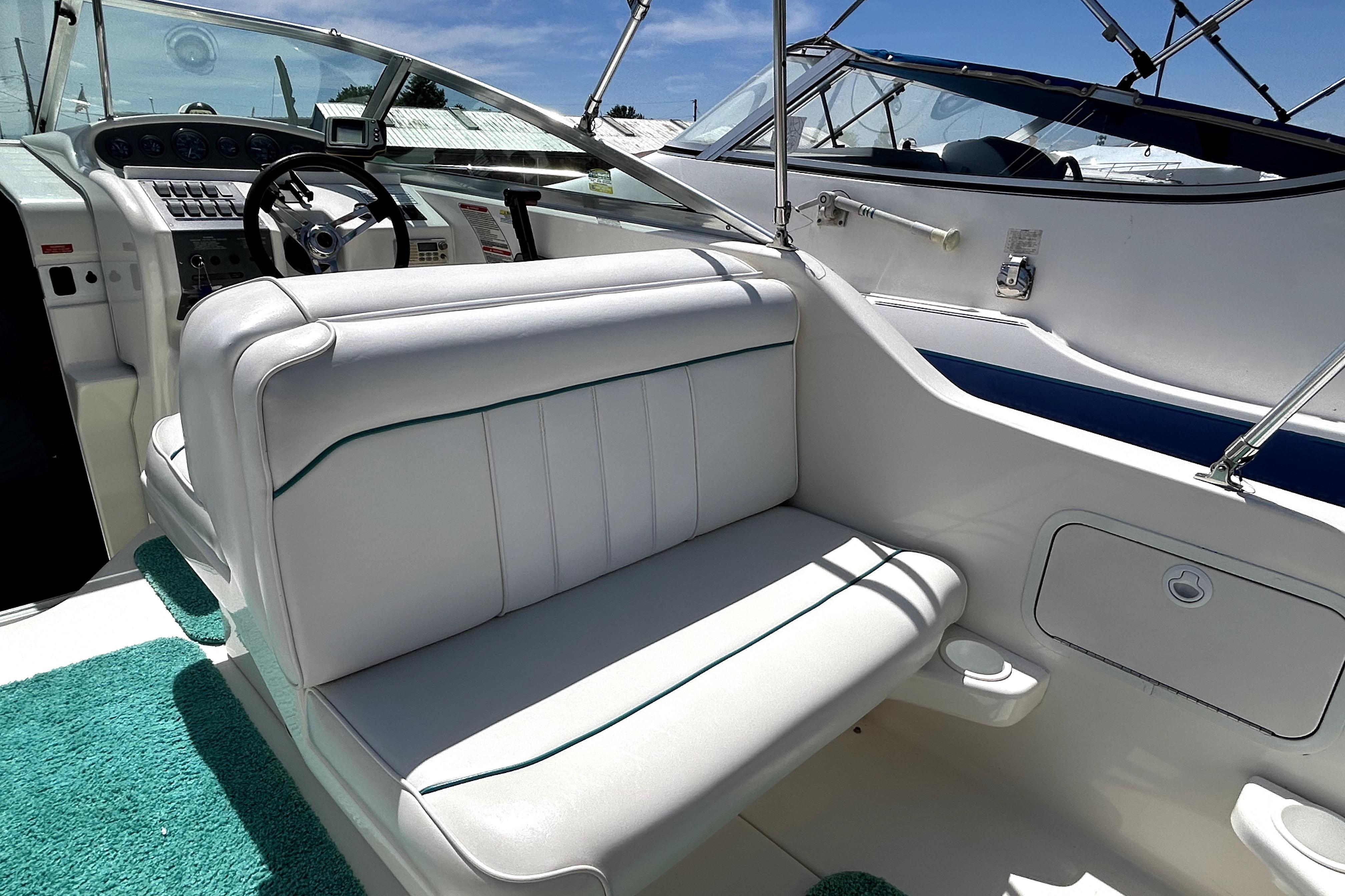 Interior view of a 1995 Sea Ray 250 Sundancer boat with white seating and dashboard.