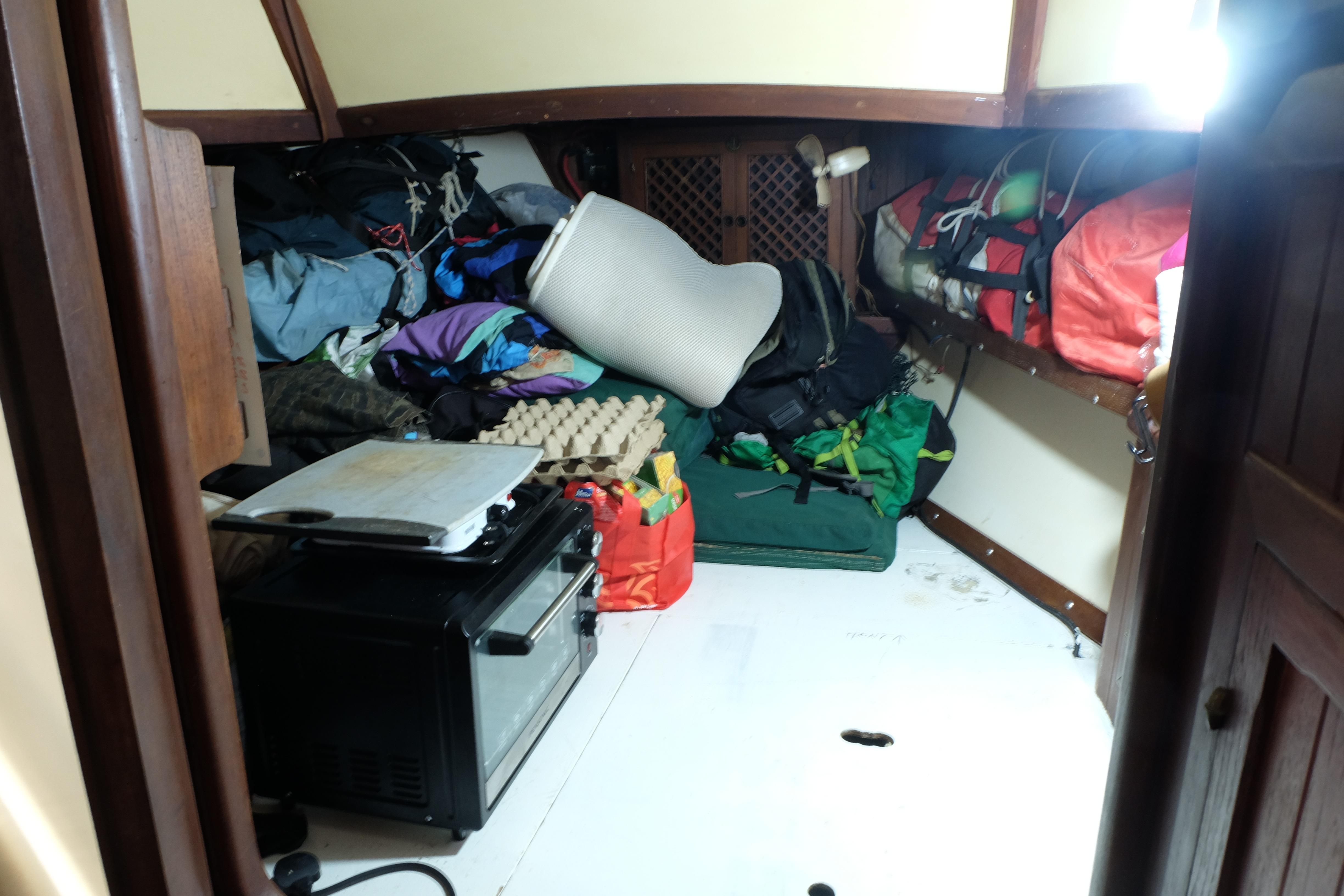 Interior of a 1979 Westwind 35 sailboat with cluttered storage space.