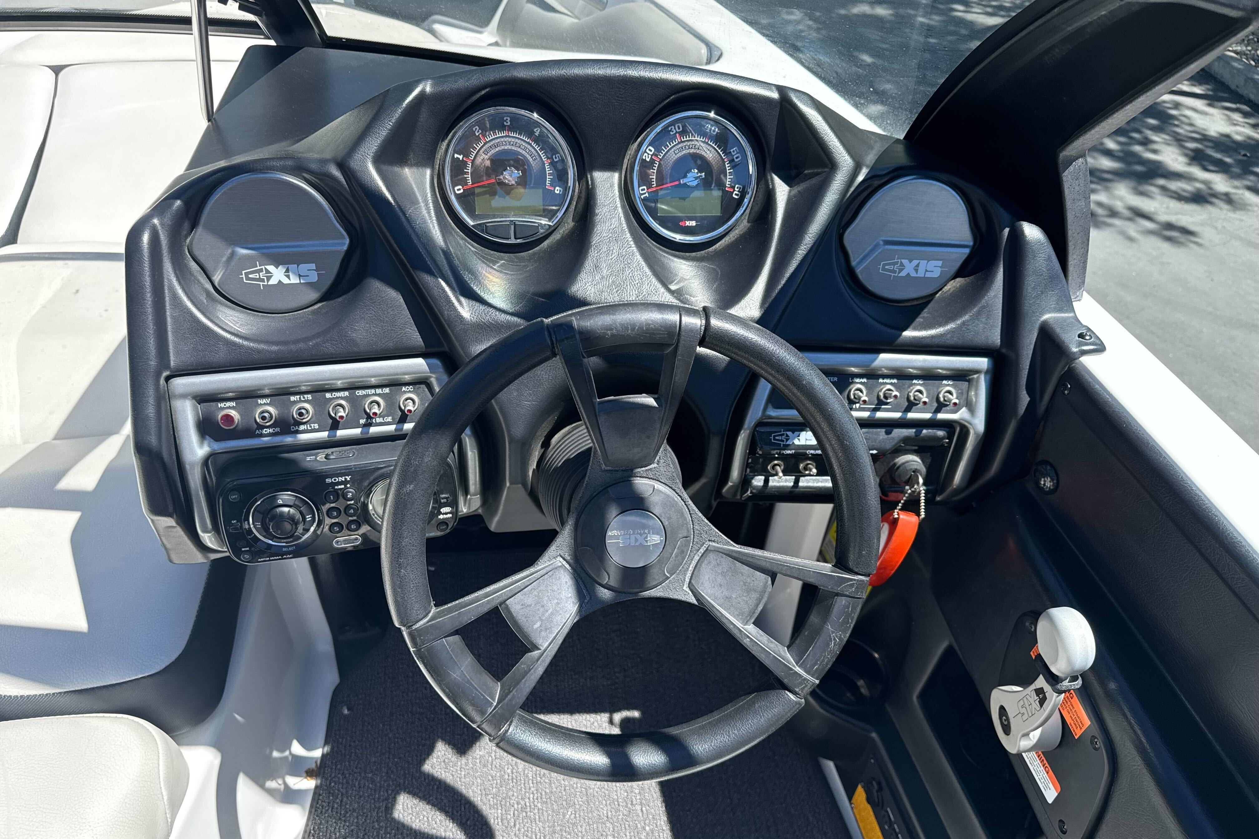 Dashboard of a 2015 Axis A20 boat with steering wheel and control panels.