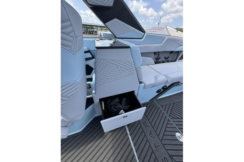 Interior of 2026 MasterCraft XStar 25 boat with open storage compartment.