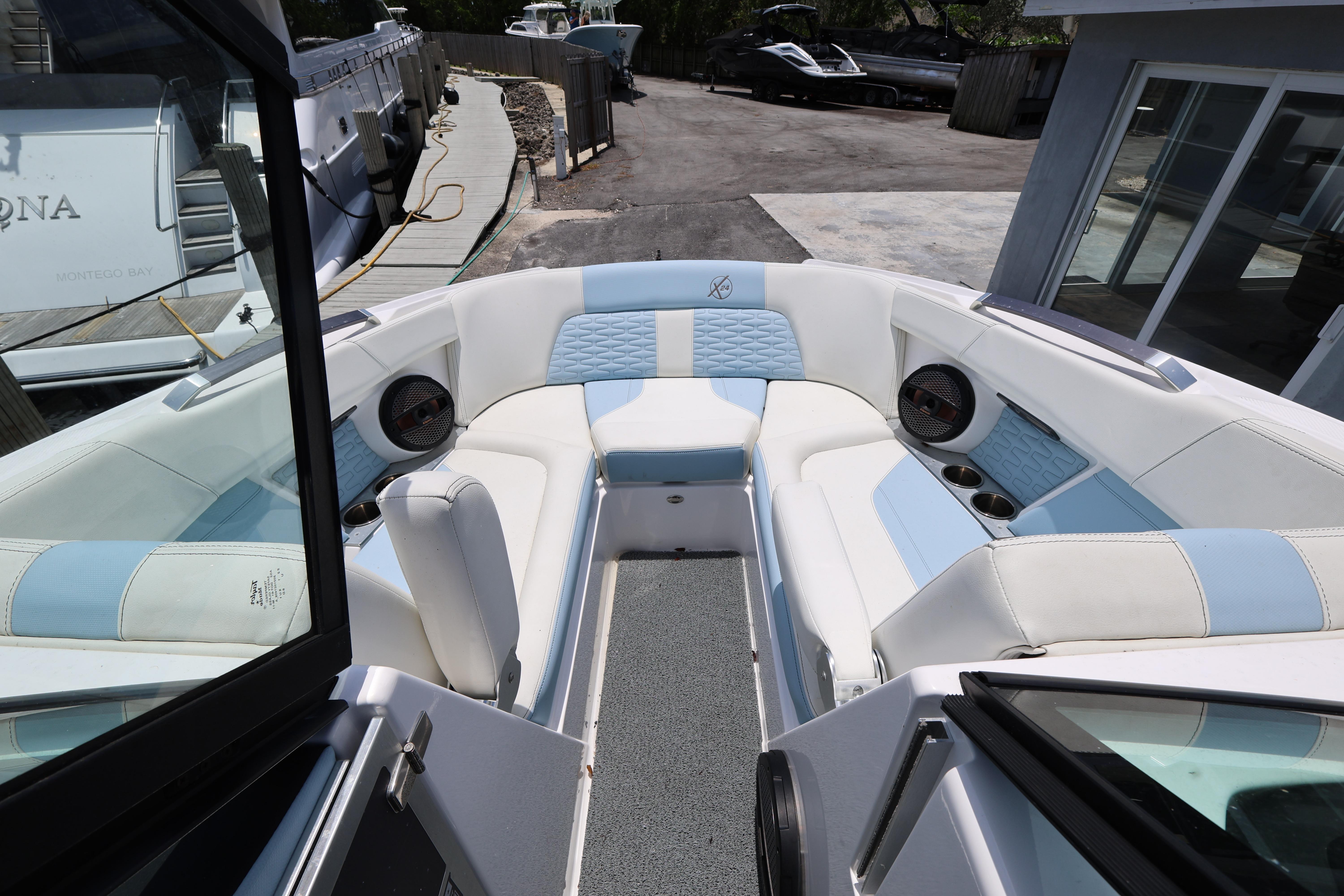 2023 MasterCraft X24 boat interior with white and blue seating, docked at marina.