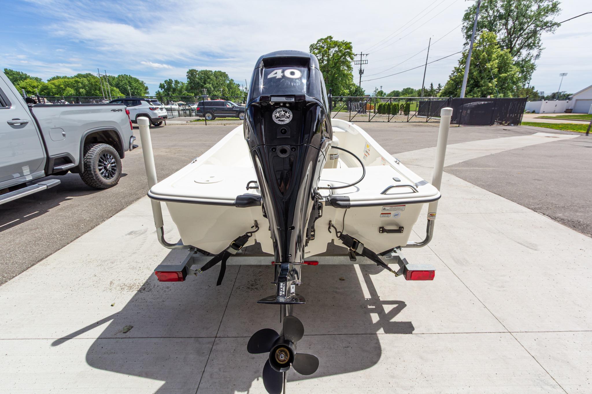 2020 Mako Pro Skiff 15 CC boat on trailer, rear view with outboard motor.