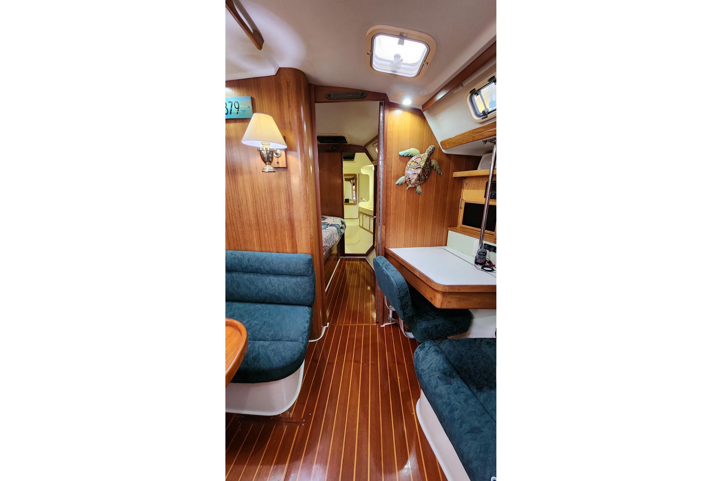 Interior of 1998 Catalina 42 MkII sailboat with wood paneling and blue seating.