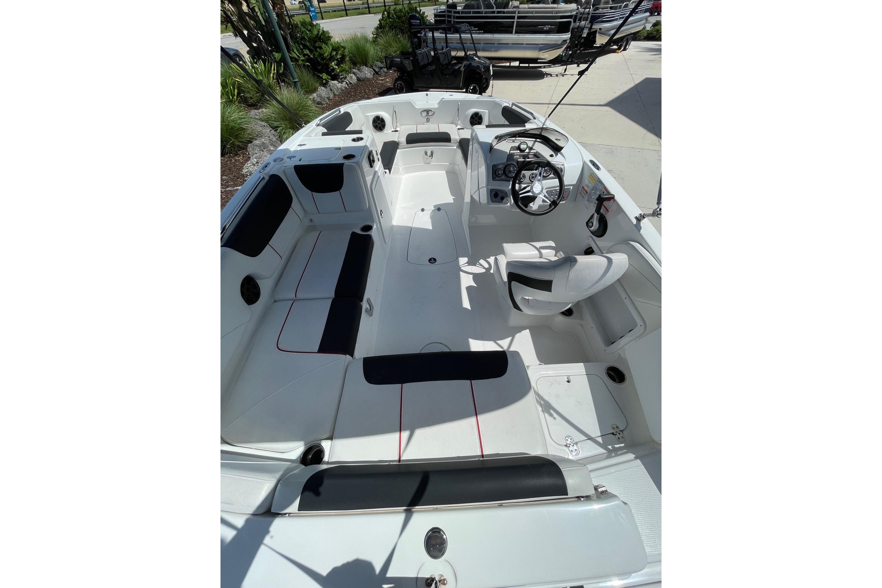 2024 Tahoe 2150 OB boat interior with seating and steering wheel, docked outdoors.
