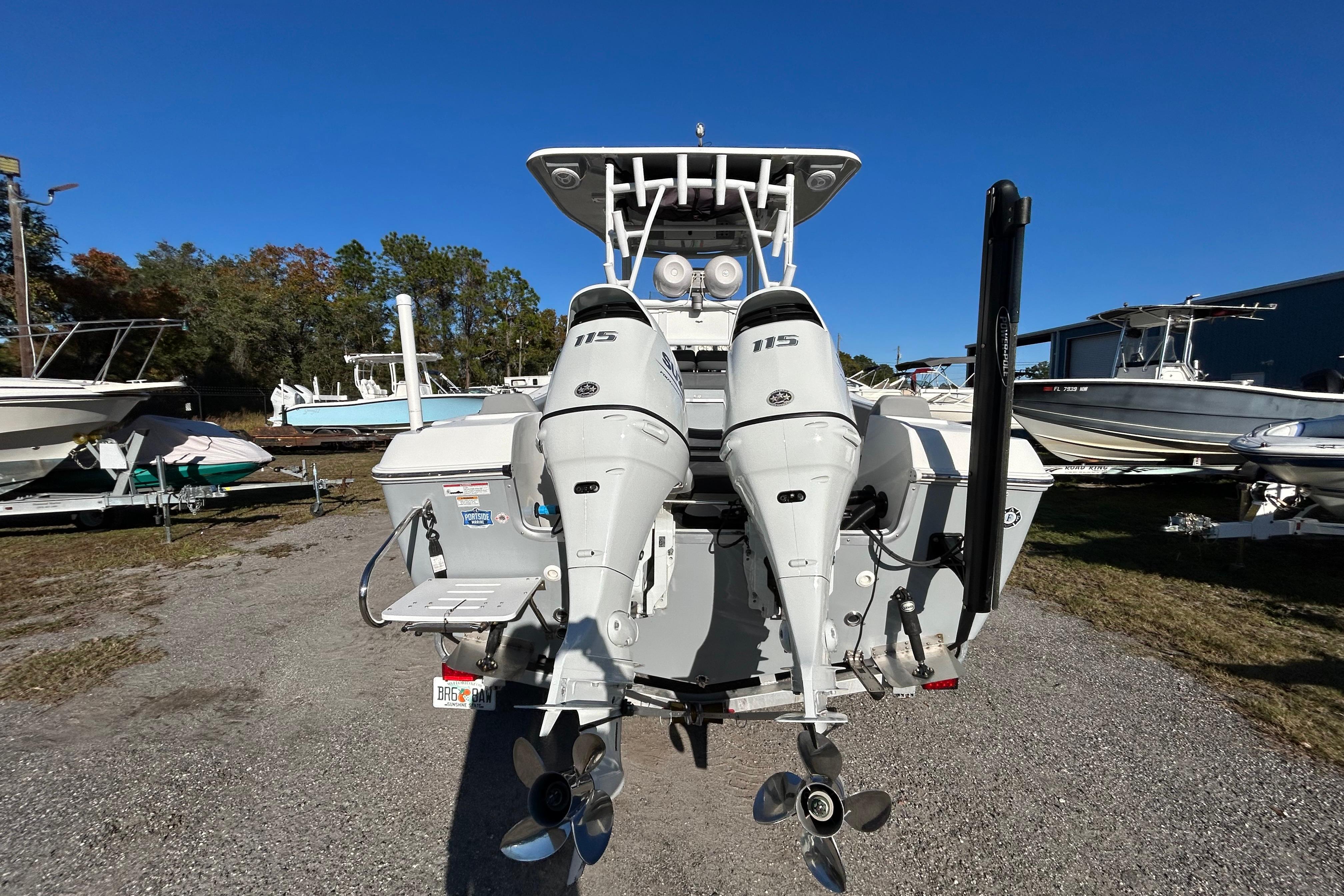 2022 Clearwater 2300 boat with dual outboard motors in a marina setting.