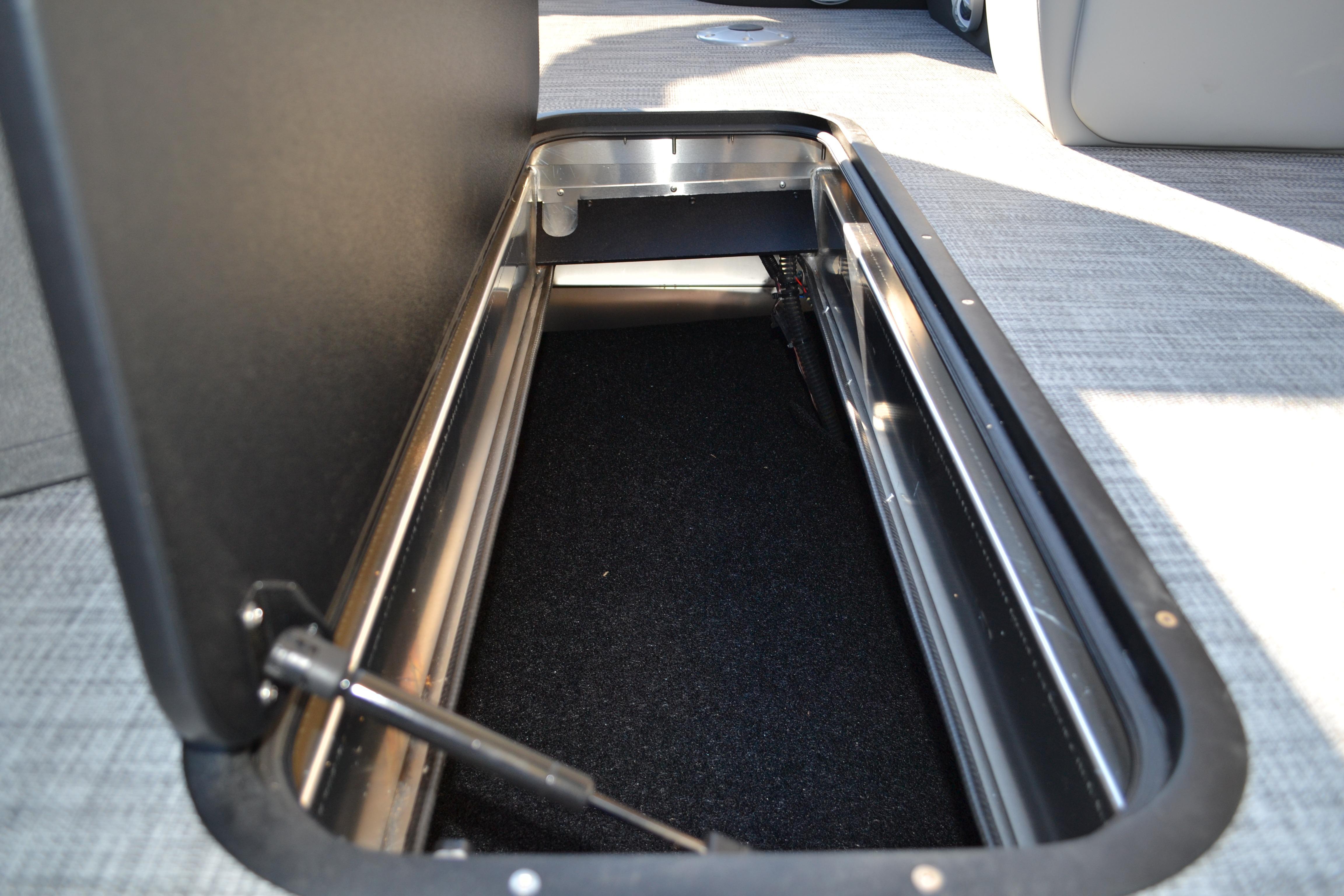 Storage compartment in 2026 Sun Tracker SportFish 22 XP3 boat, featuring carpeted interior.