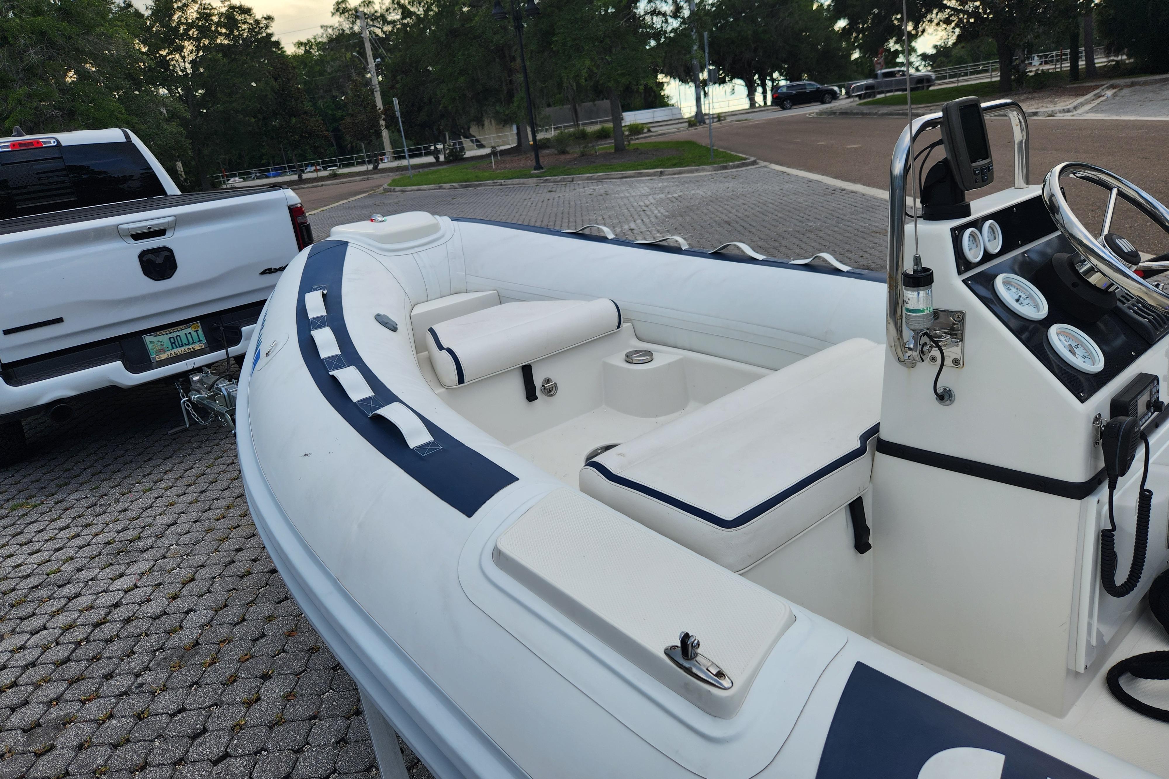 2019 Novurania DL 400 boat hitched to a white truck in a parking area.