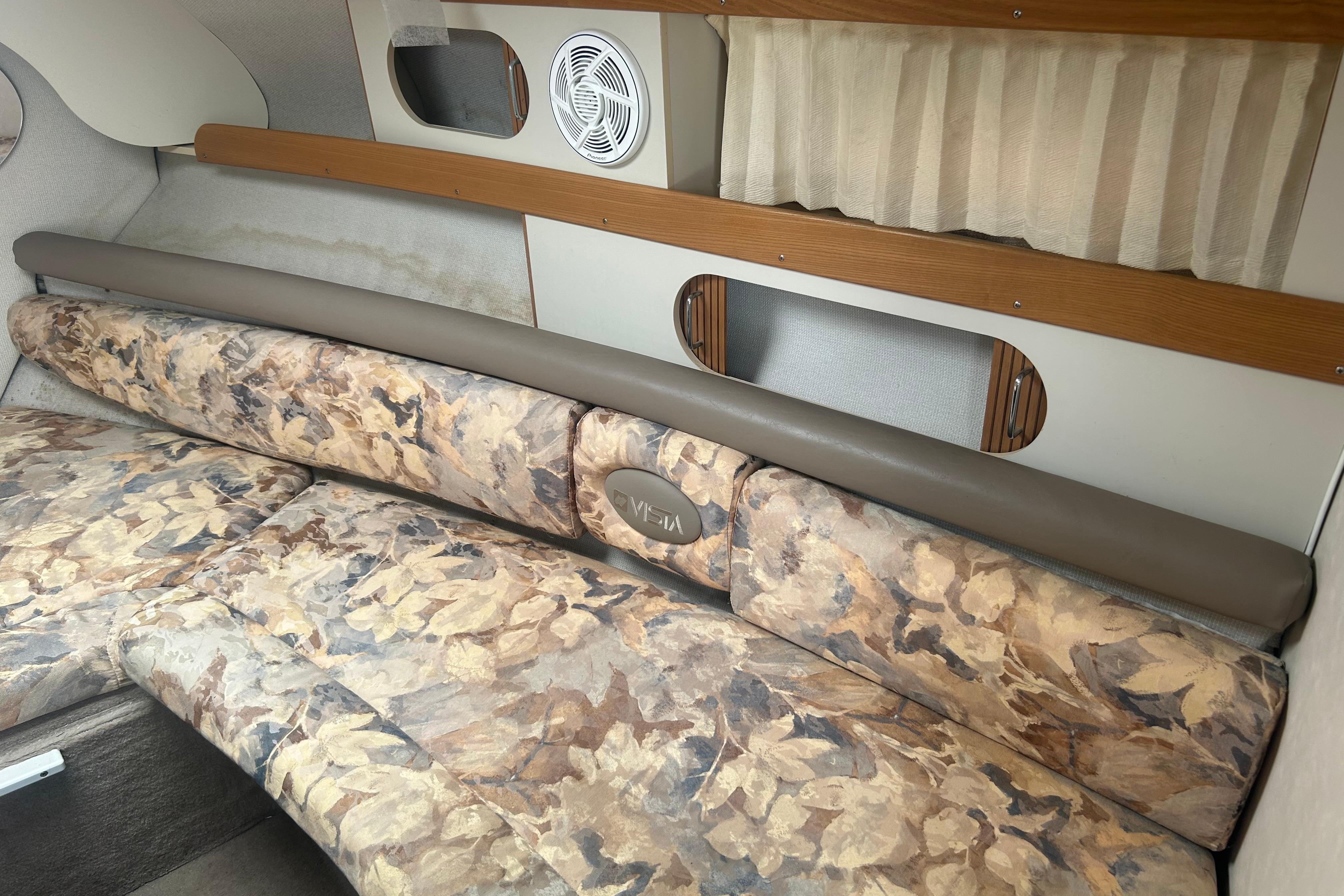 Interior of a 1998 Four Winns 258 Vista boat with floral-patterned seating.