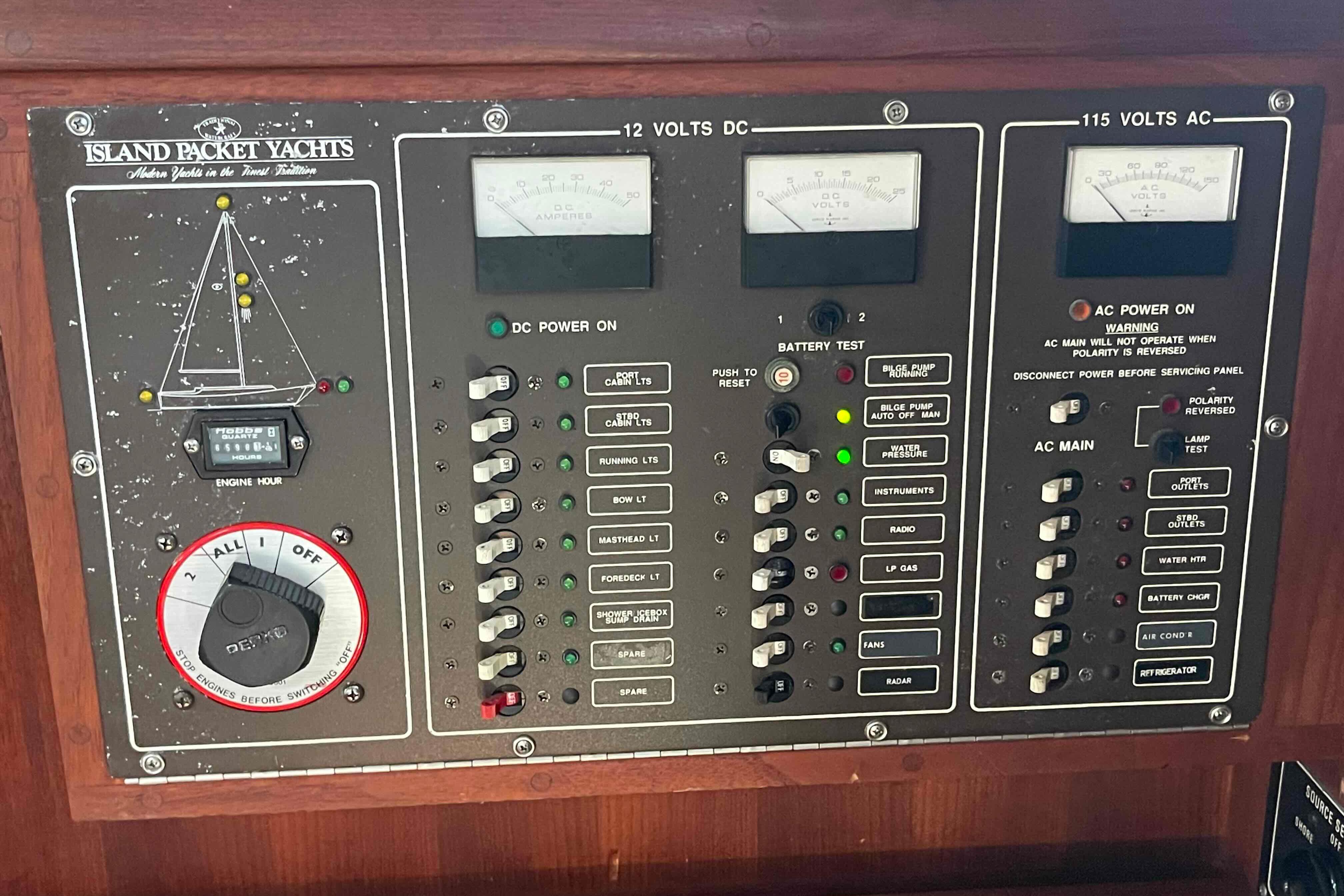 Control panel of a 1989 Island Packet 35 yacht, featuring various switches and gauges.