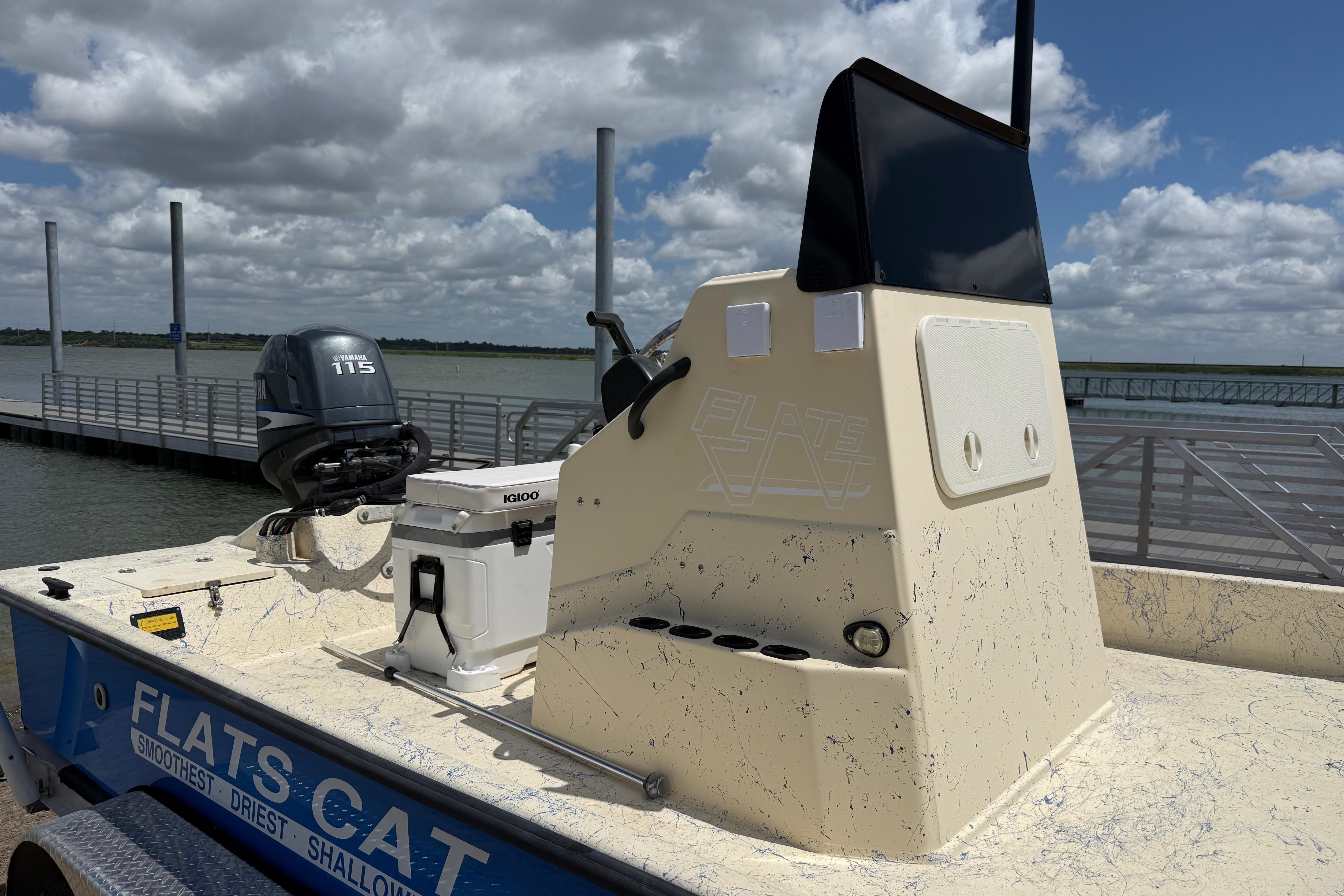 2007 Flats Cat 19 boat with Yamaha 115 engine, docked under a cloudy sky.
