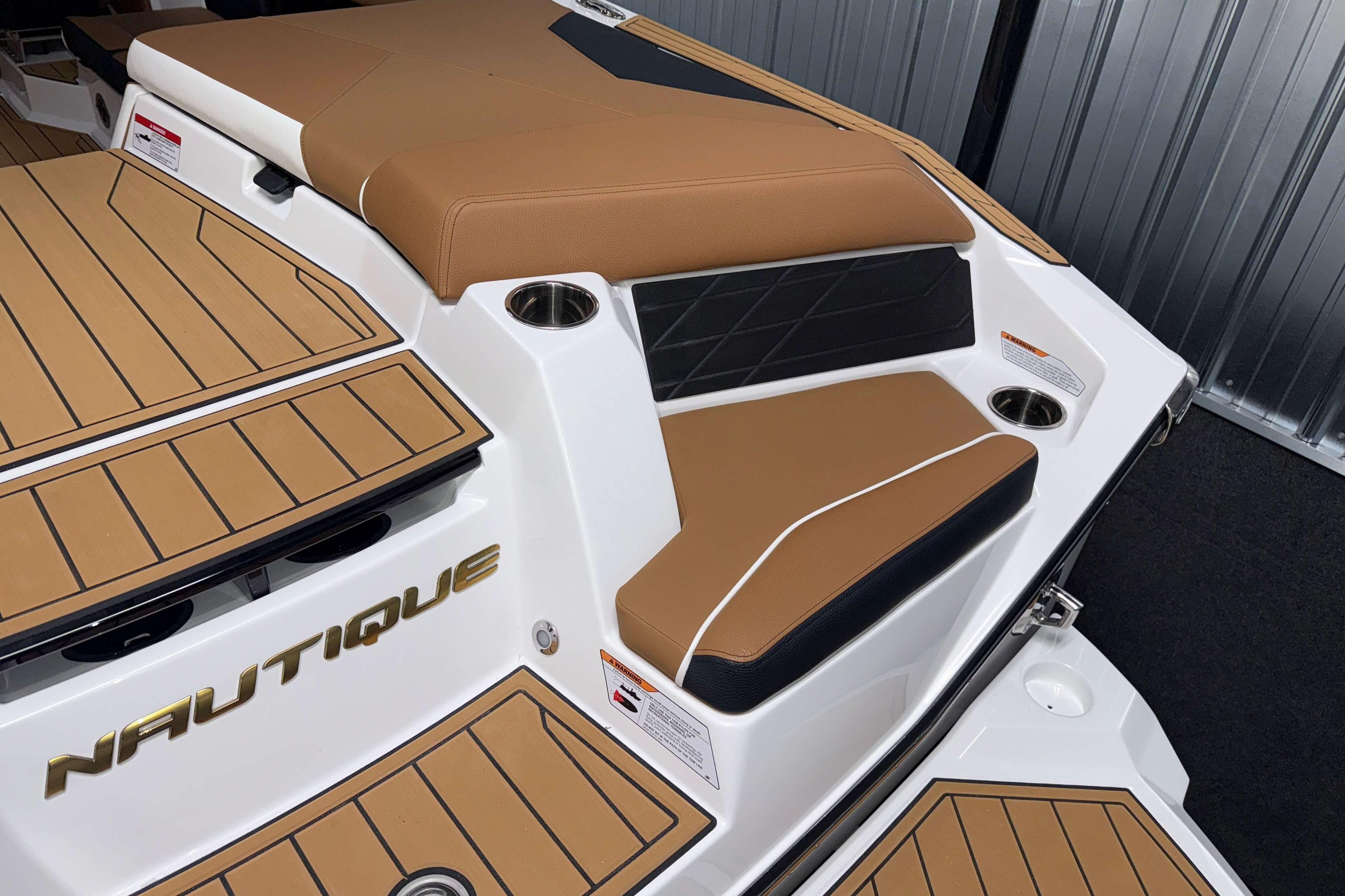 2026 Nautique Super Air Nautique S23 boat interior with tan seating and cup holders.