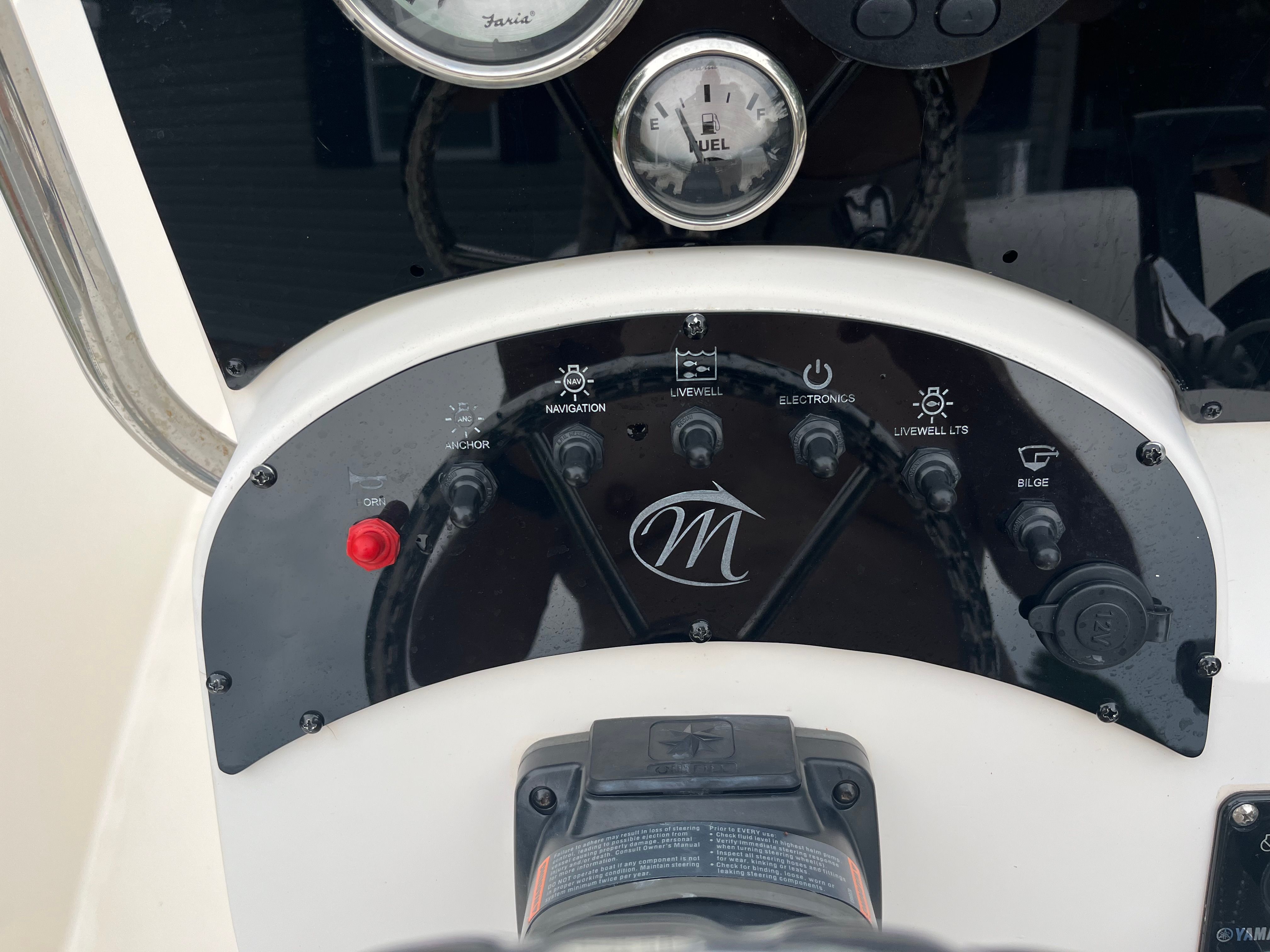 Close-up of a boat's control panel with various switches and gauges.