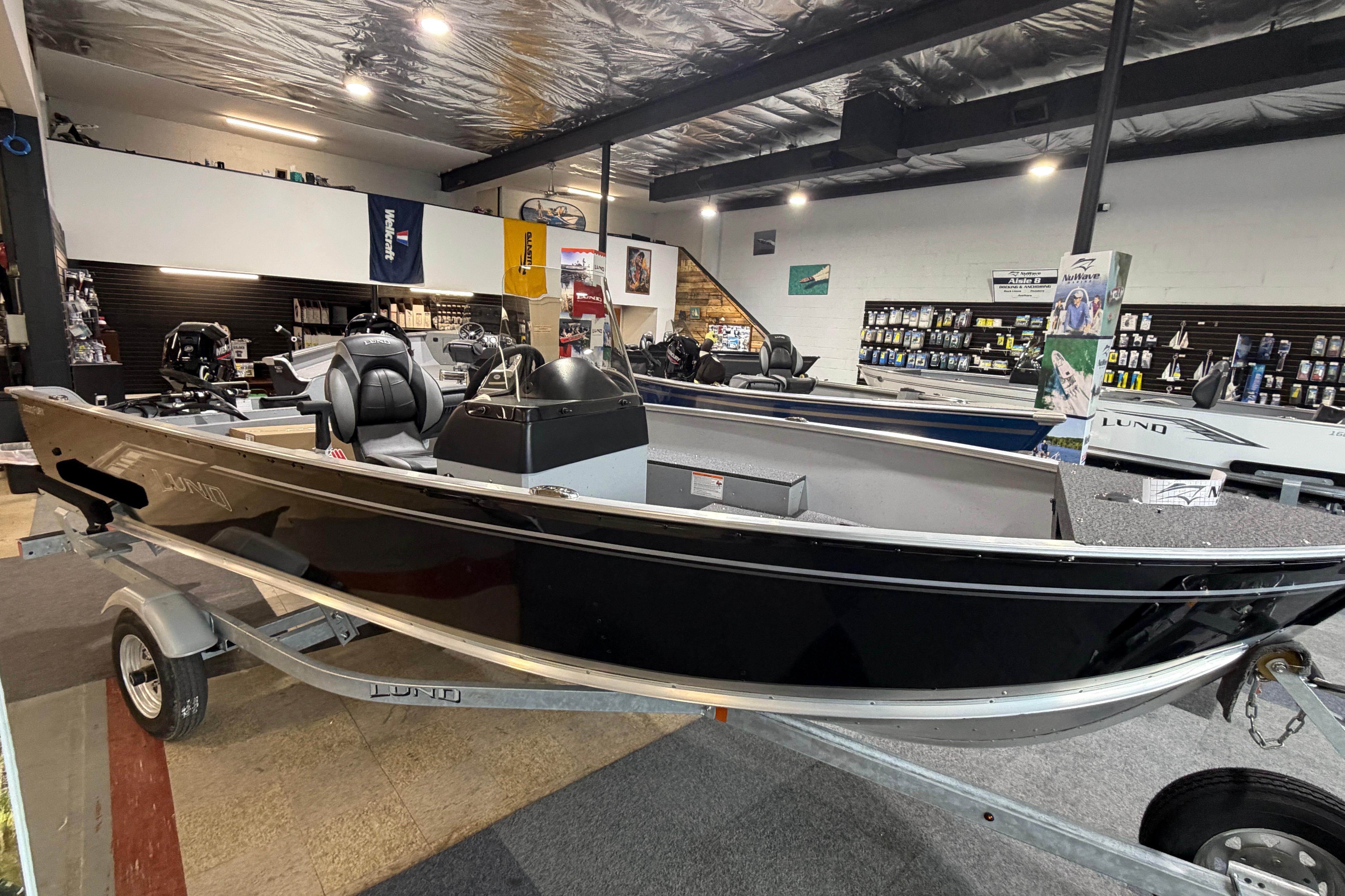 2027 Lund 1600 Fury SS boat displayed in a showroom, featuring sleek black design.