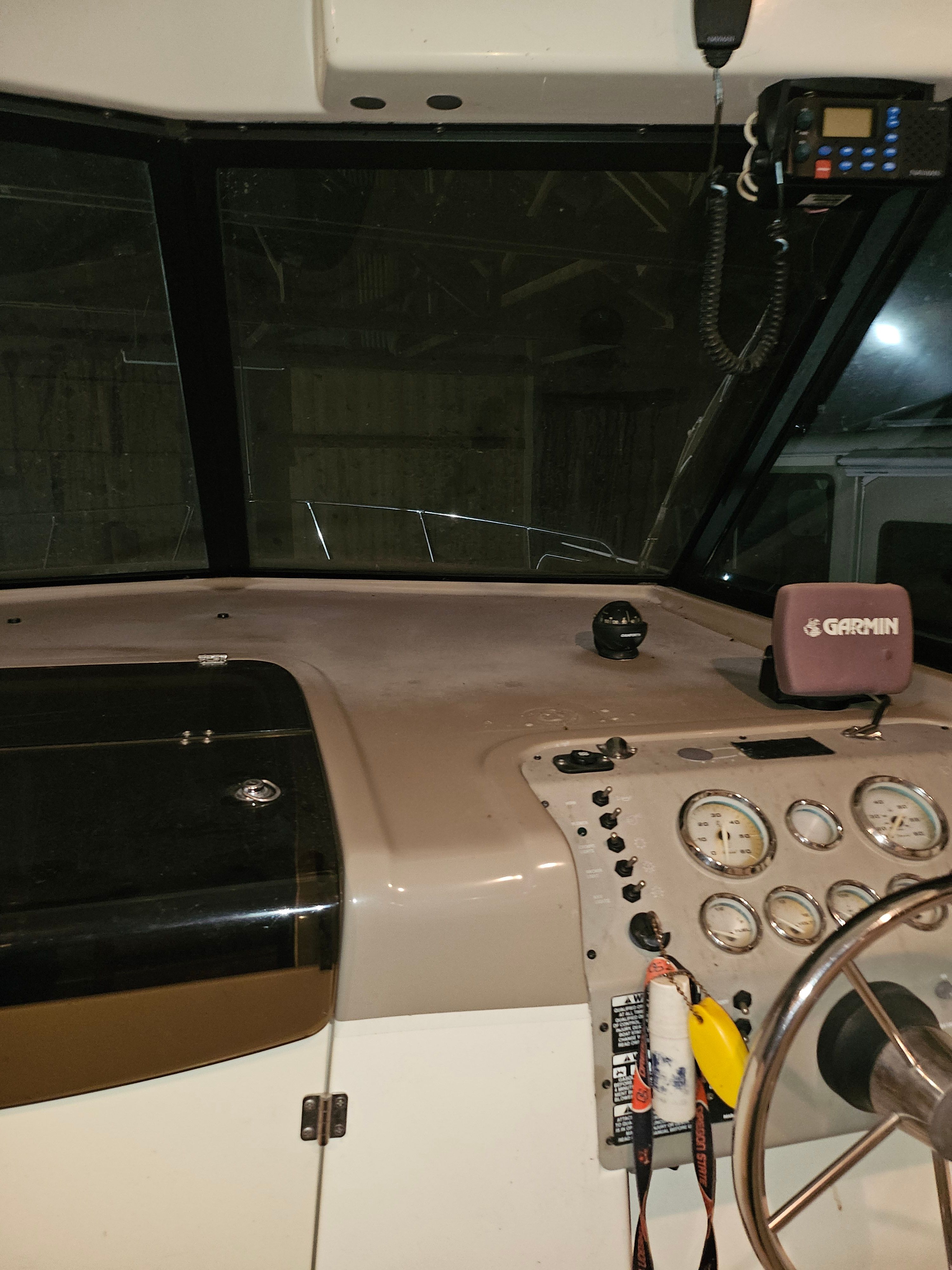 The image shows the cockpit of a 2005 Bayliner 242 Ceara with instruments and steering.