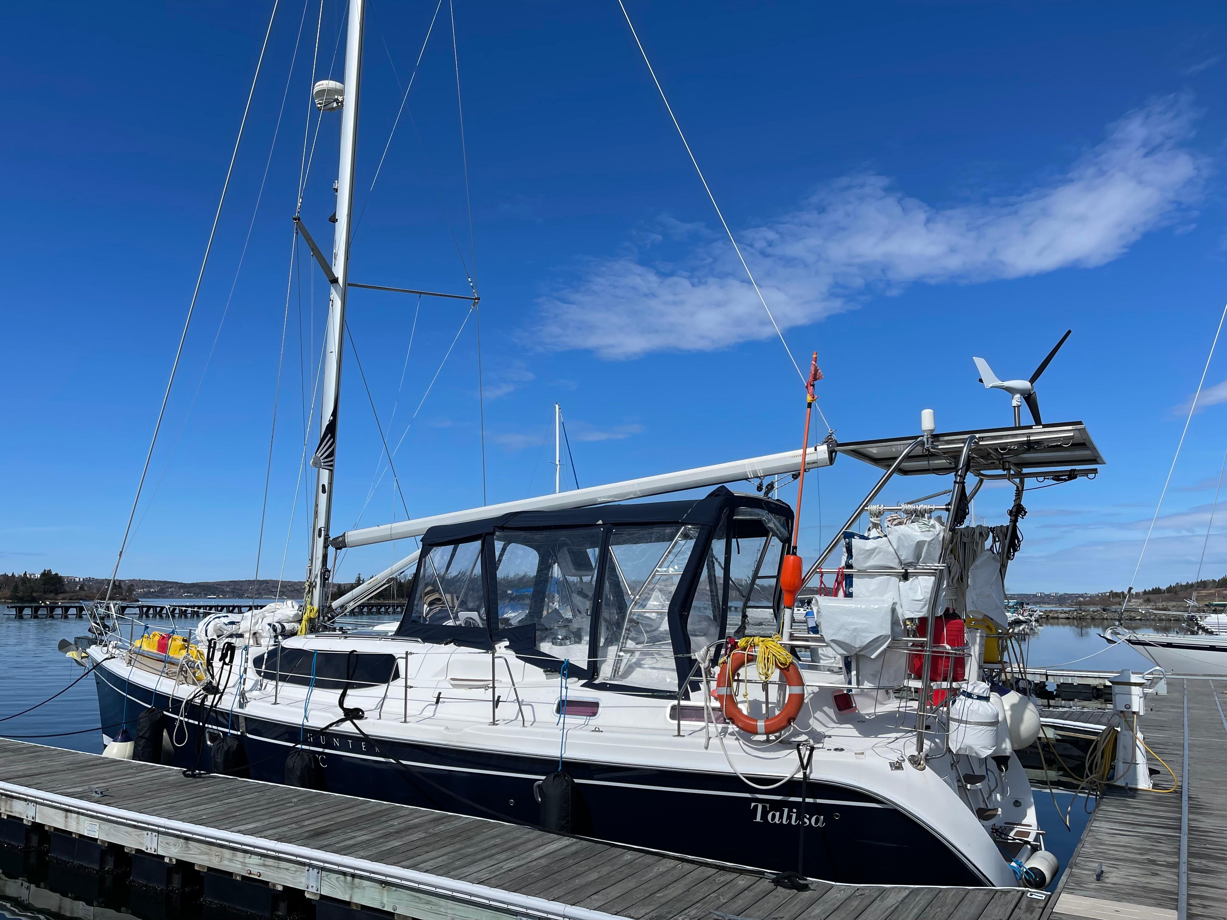 Sailboat docked at marina, Hunter 45cc model, 2006, under clear blue sky.