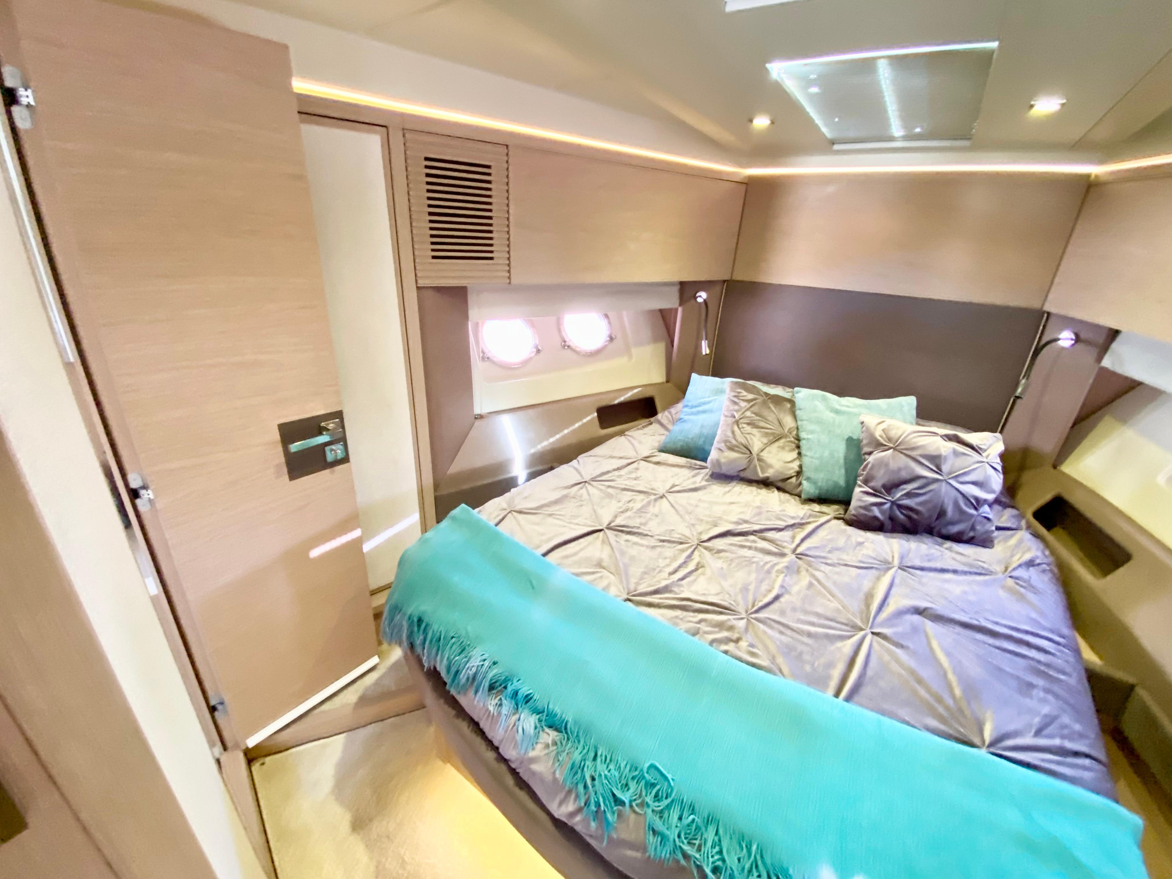 Luxurious 2015 Monte Carlo MC5S yacht bedroom with modern decor and cozy bedding.