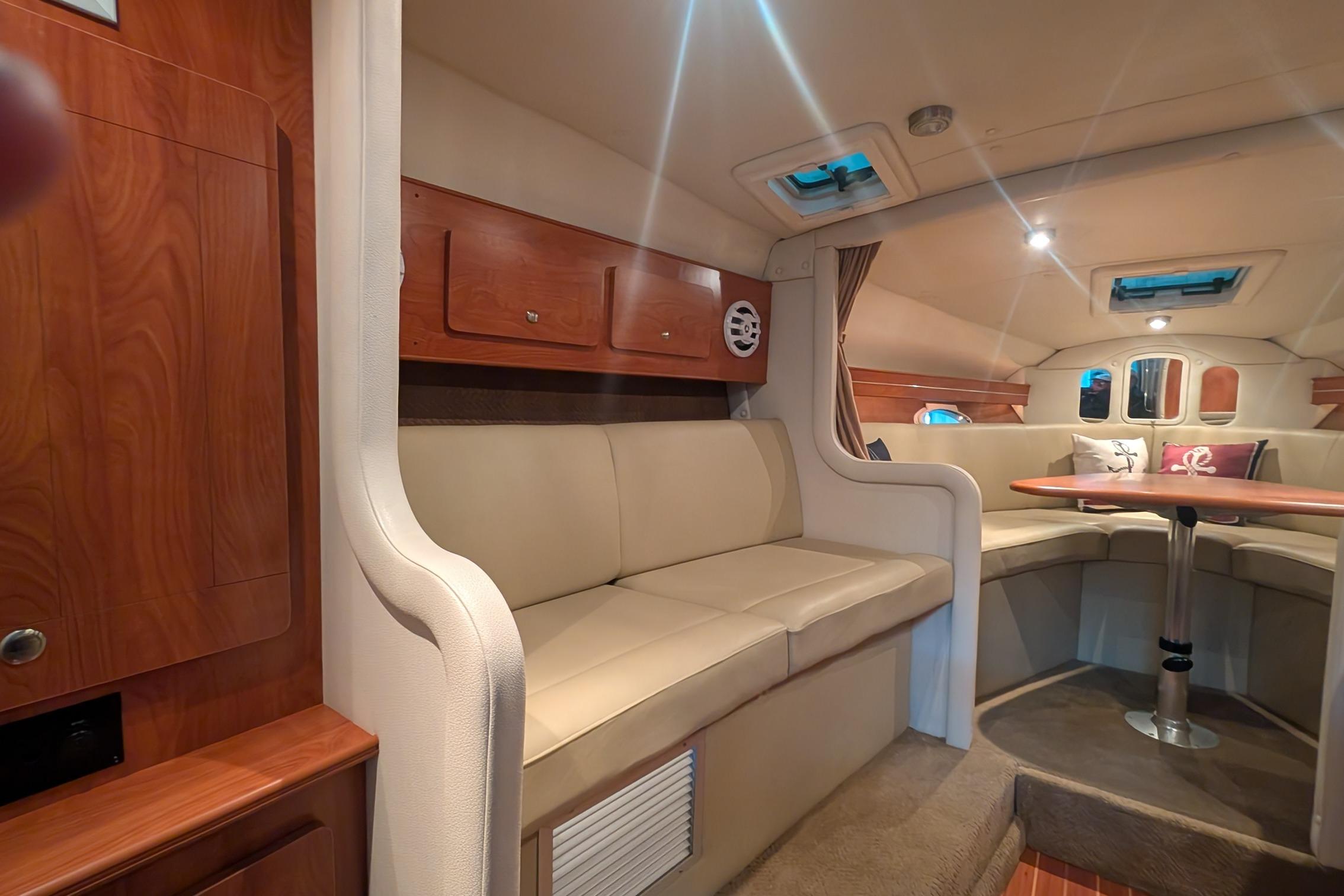 Interior of 2006 Rinker 300 Express Cruiser with beige seating and wooden accents.