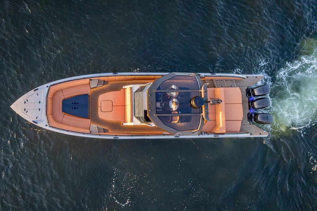 Aerial view of 2023 DeKoning 43 luxury yacht cruising on water.