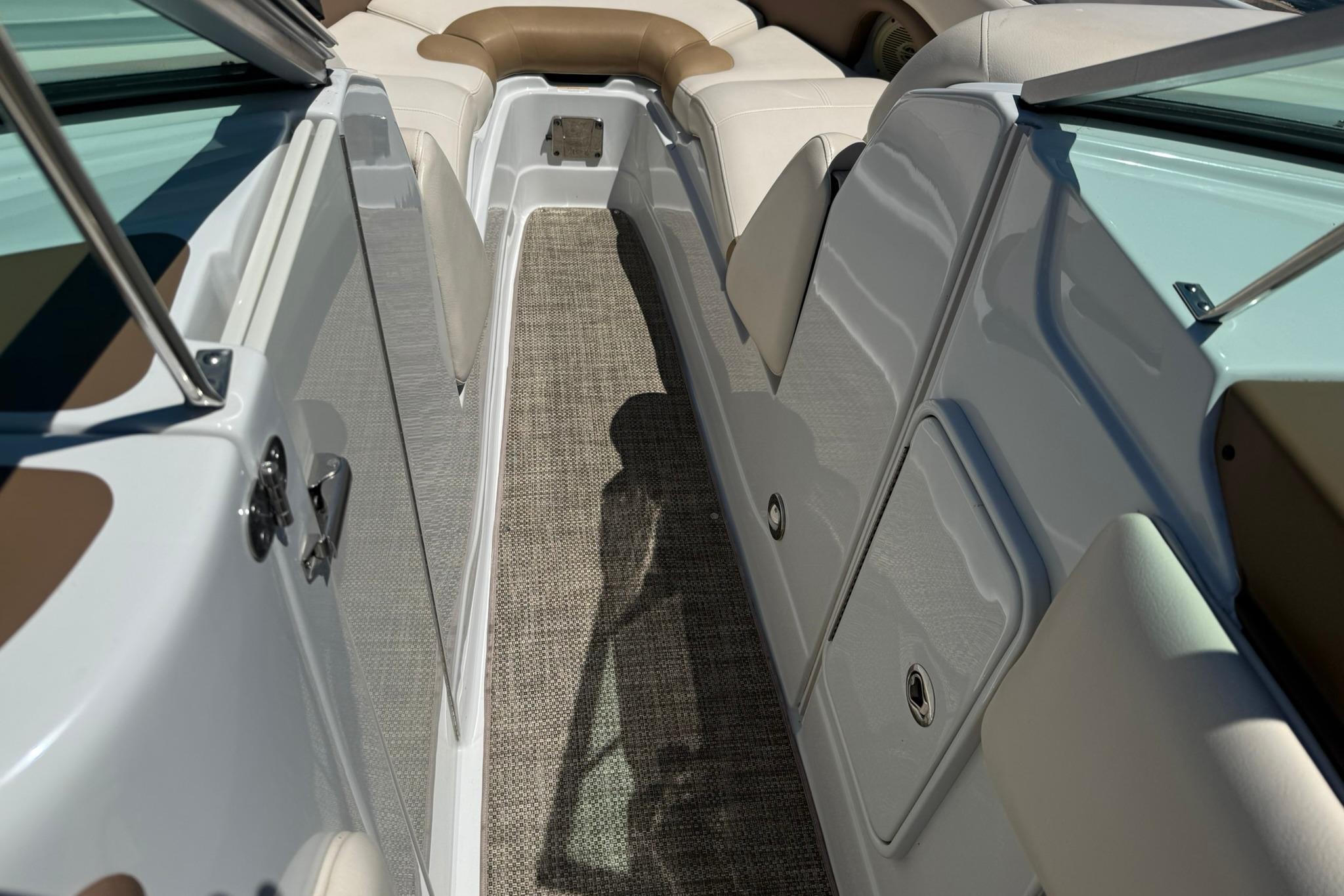 2016 Crownline 255 SS boat interior with beige seating and carpeted walkway.