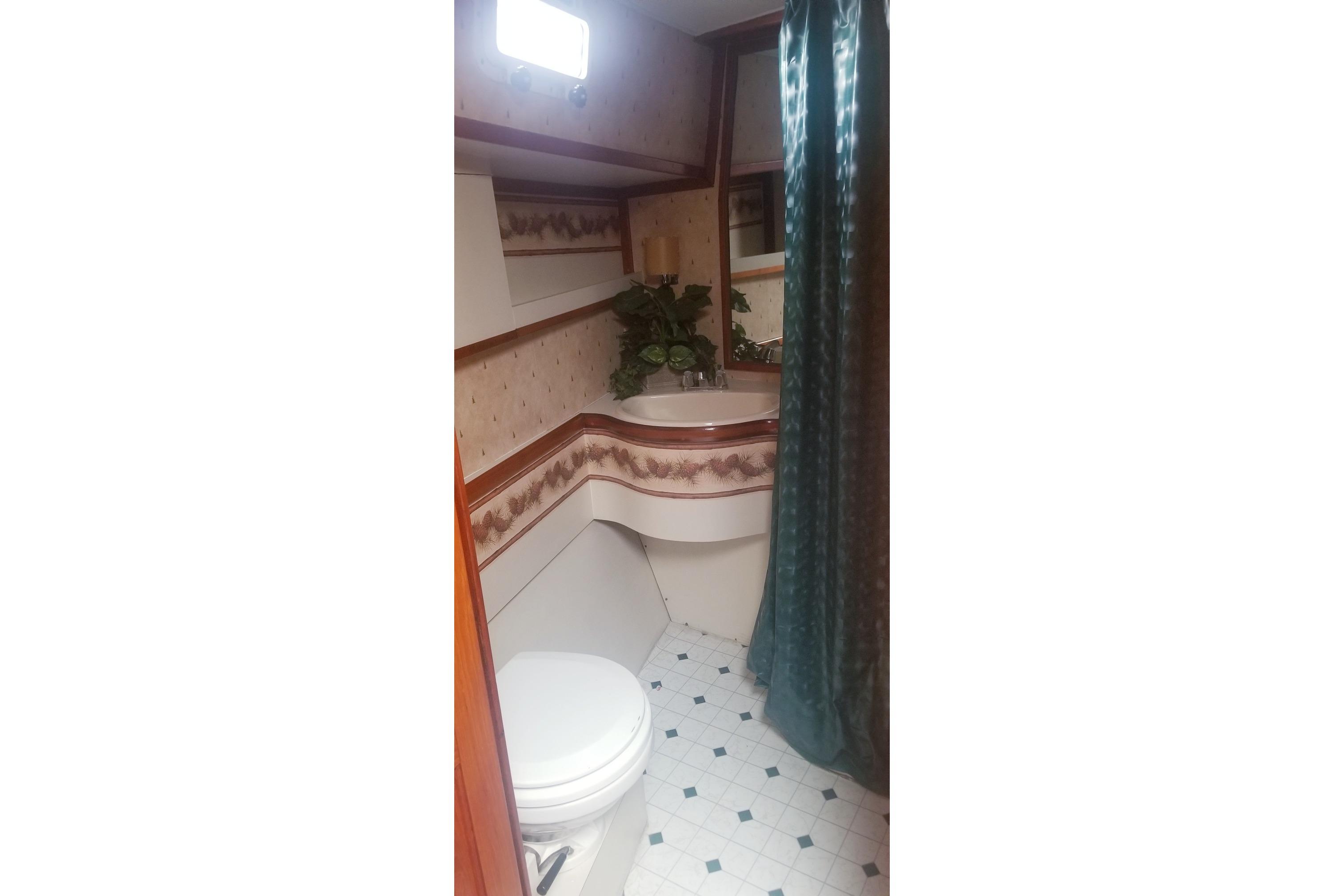 1984 Gulfstar 49 Motor Yacht bathroom with floral wallpaper and green shower curtain.