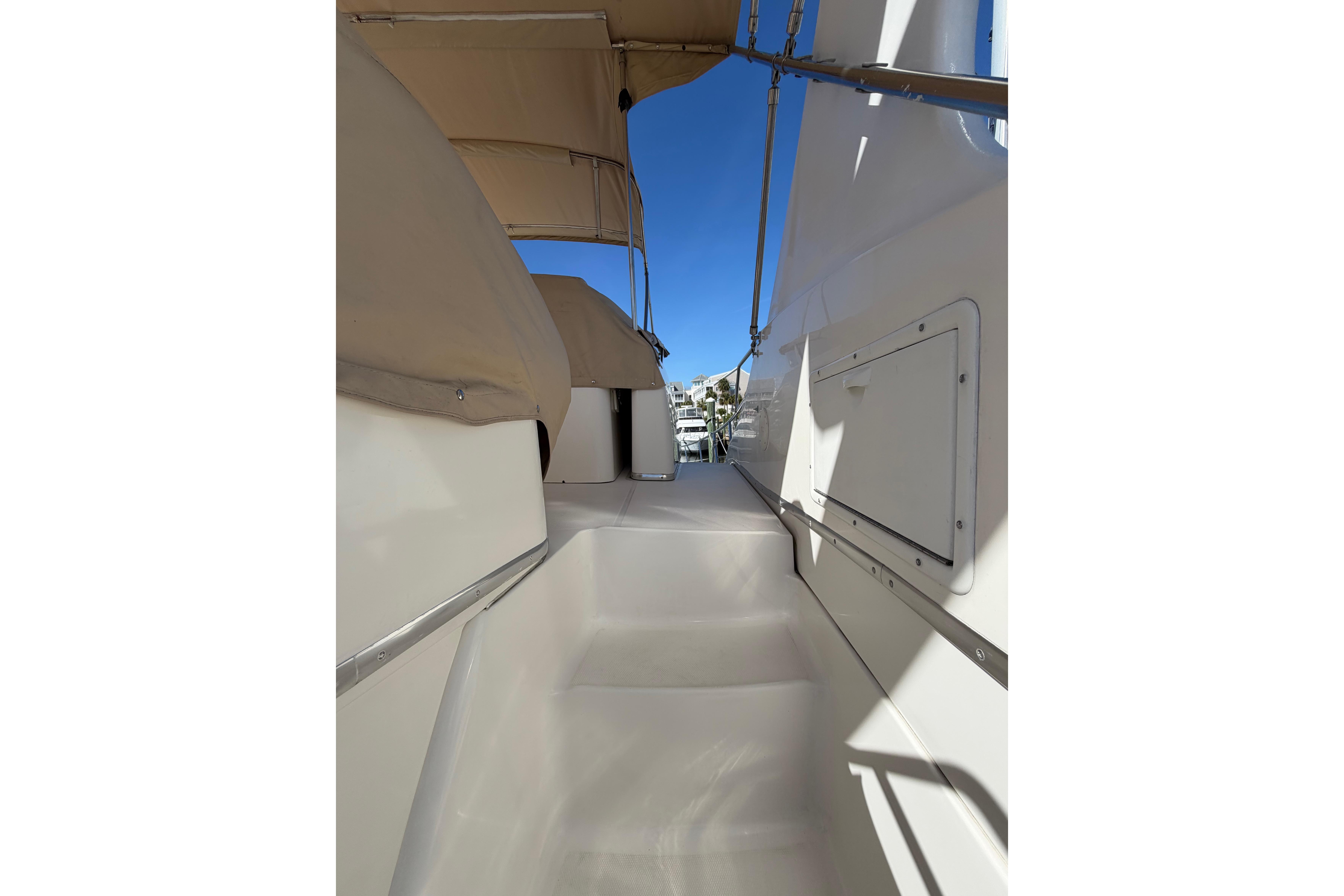 2001 Silverton 410 Sport Bridge yacht deck with beige canopy and clear blue sky.