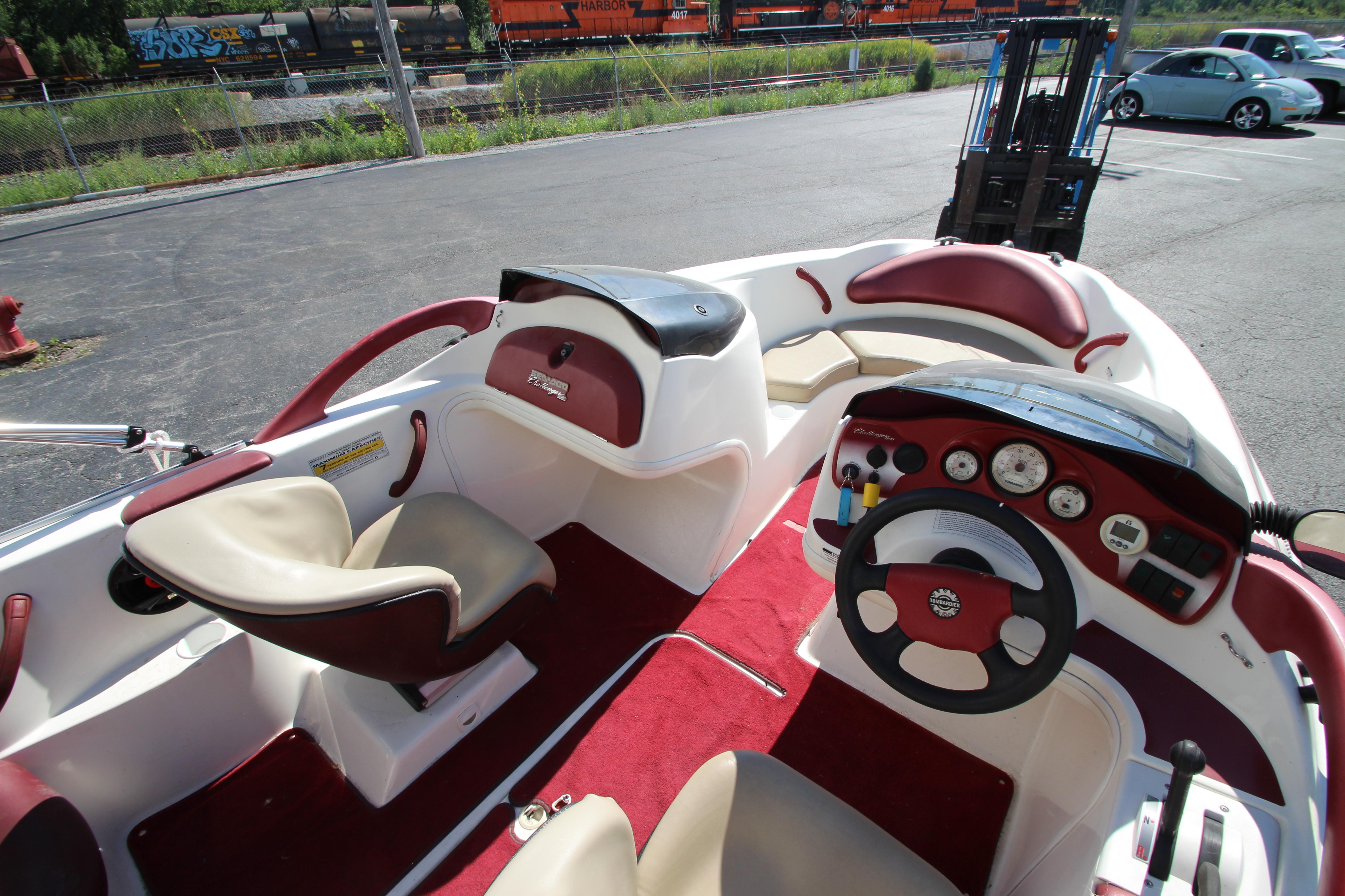 Interior of a 2000 Bombardier Challenger 1800 boat with red and beige seating.