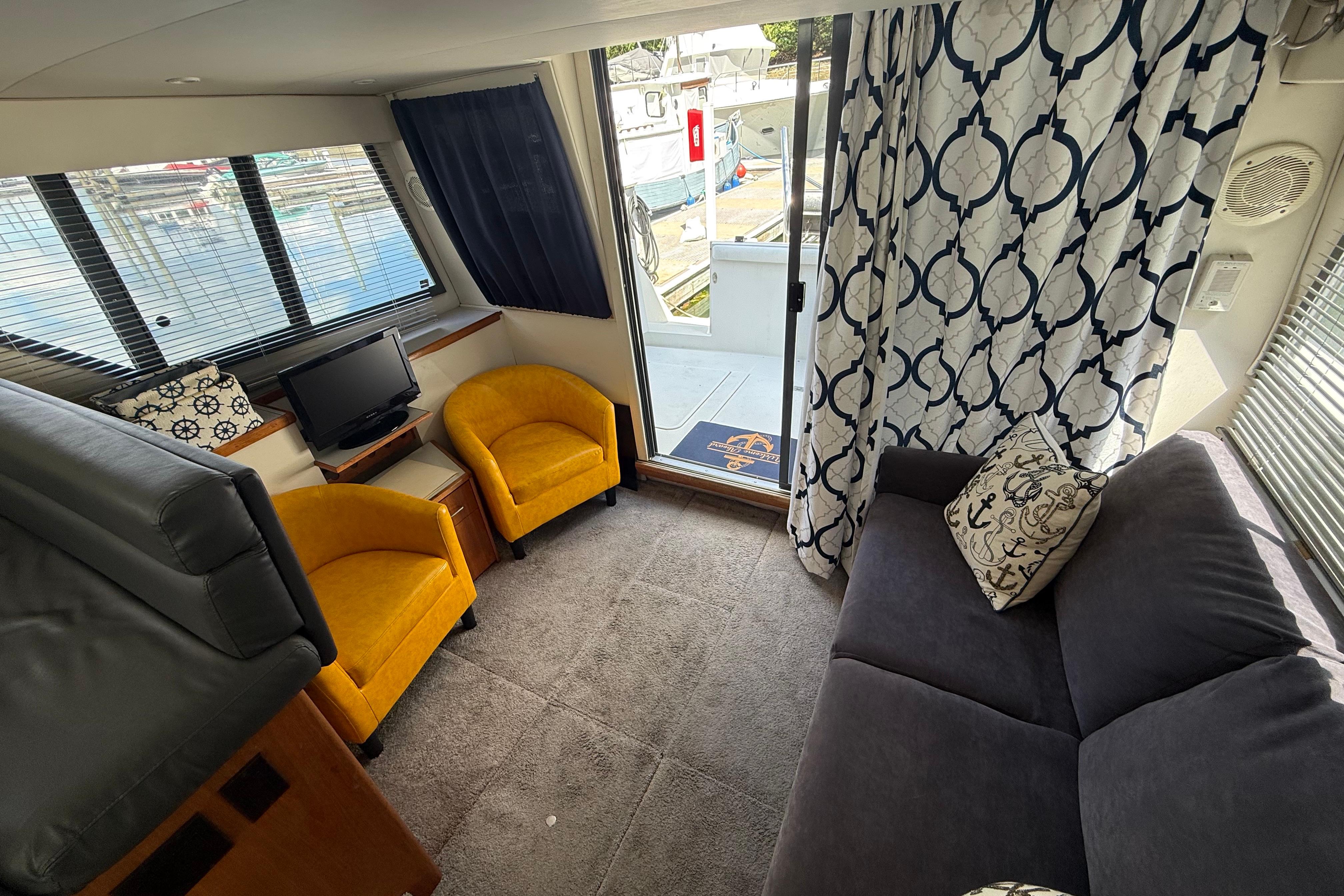 Interior of 1995 Carver 370 Voyager yacht with cozy seating and nautical decor.
