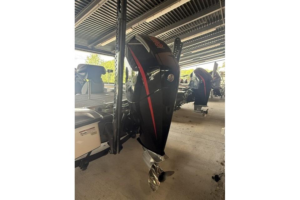2023 Caymas CX 21 PRO boat with powerful outboard motor in a covered storage area.