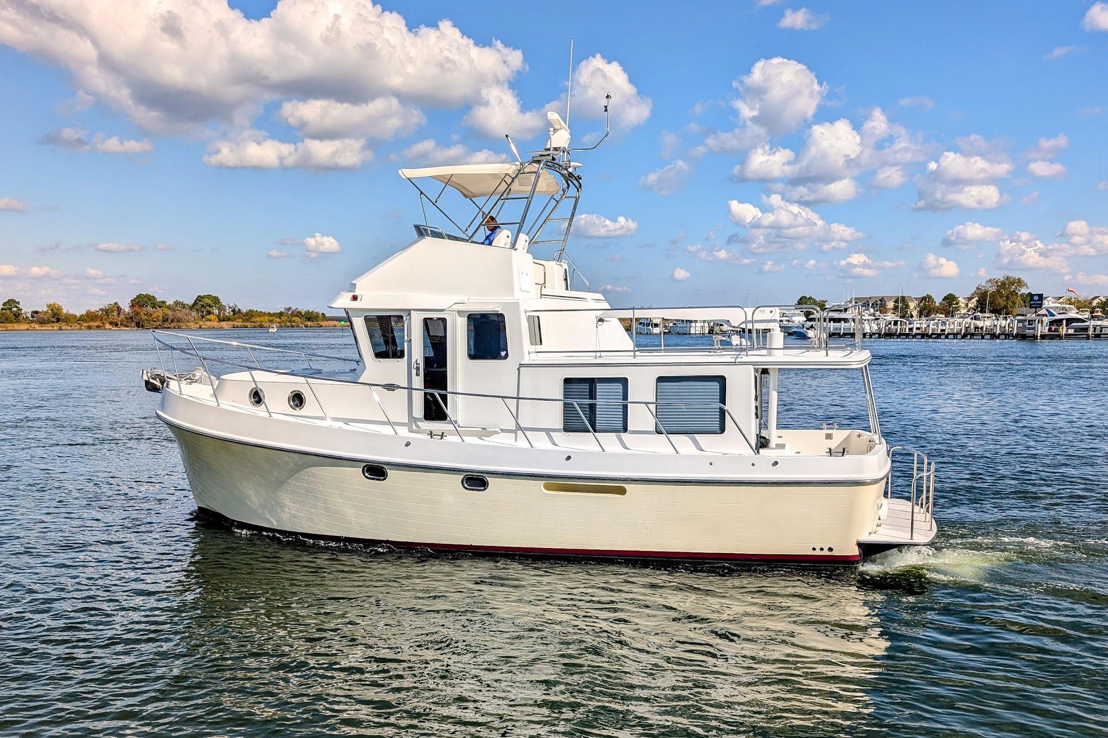 2015 American Tug 435 cruising on a sunny day with blue skies and calm waters.