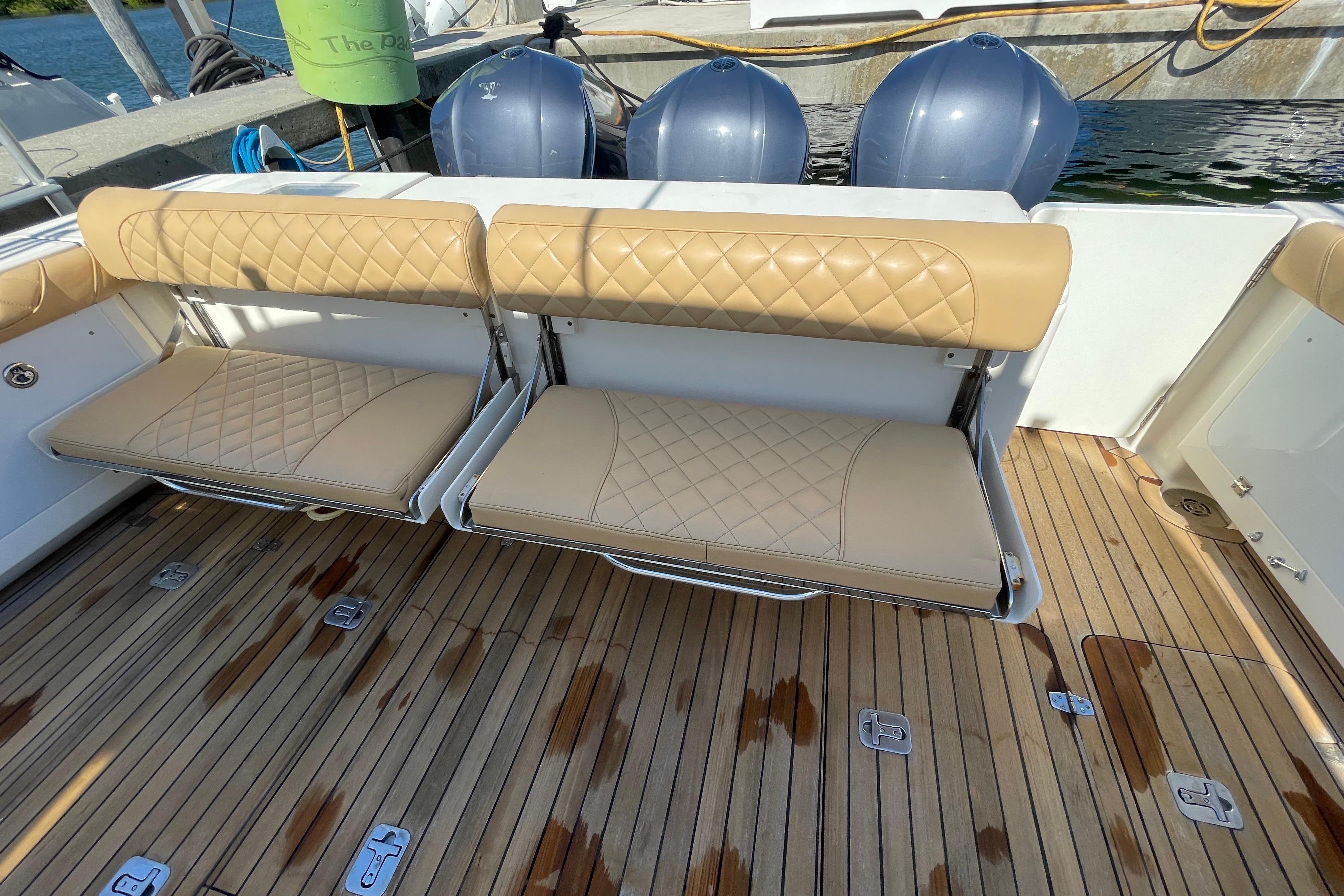 2010 Pursuit OS 375 Offshore boat with tan cushioned seats and wooden deck.