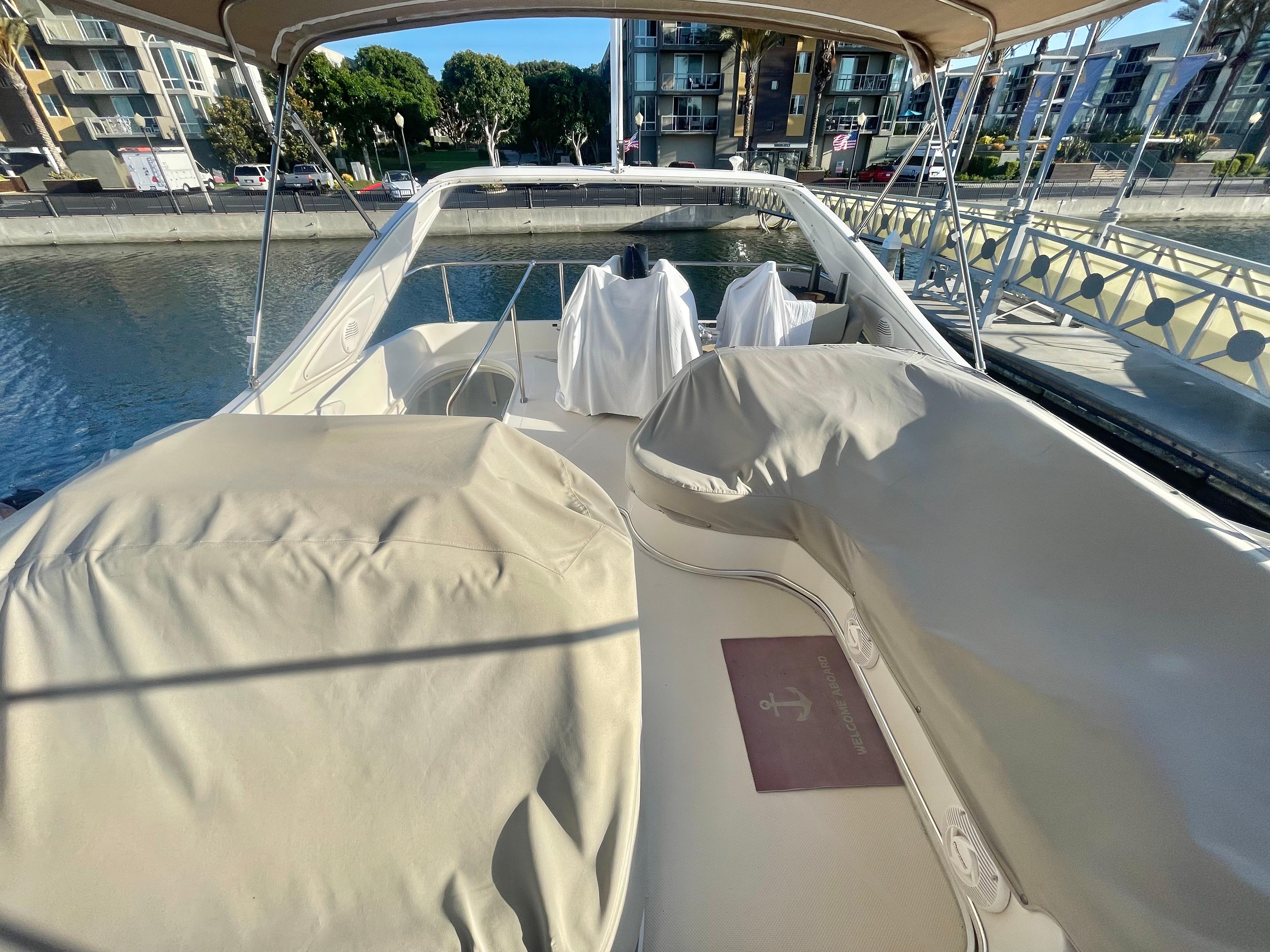 1998 Maxum 4100 SCA yacht deck with covered seating, docked in a marina.