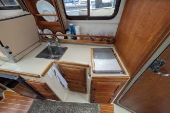 Galley with wooden cabinets and stainless-steel sink.
