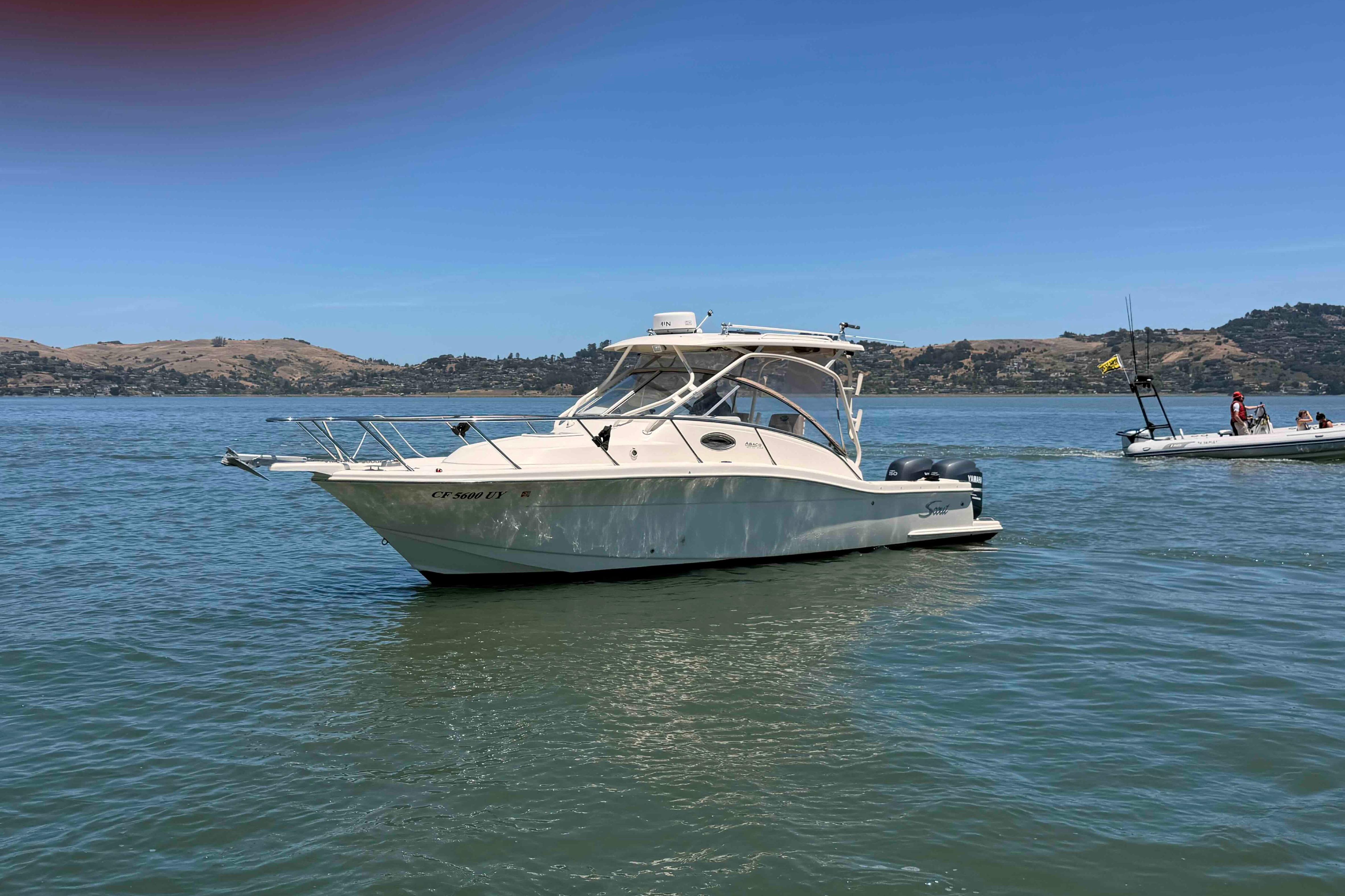 2007 Scout 262 Abaco boat on calm water with scenic hills in the background.