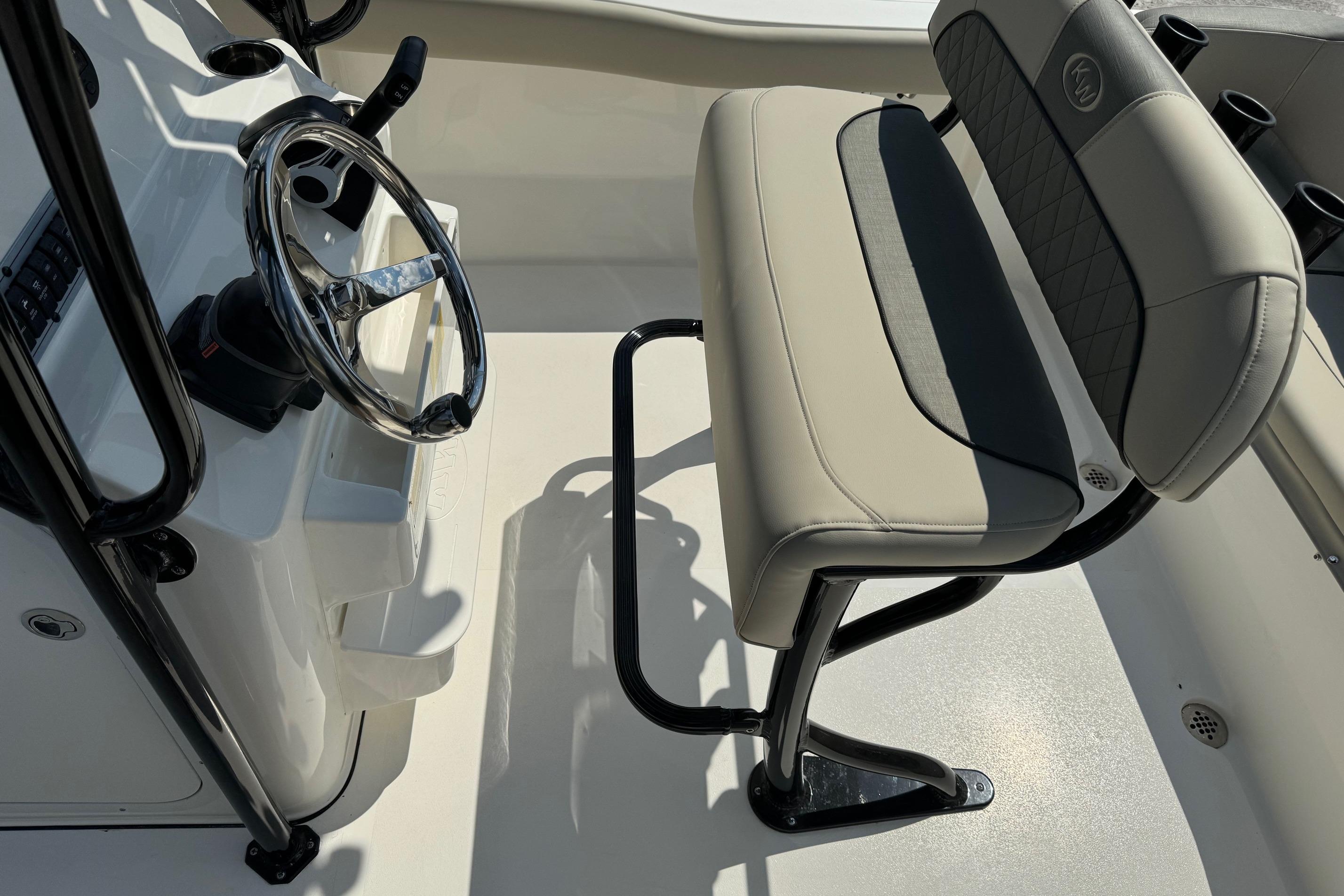2025 Key West 203 FS boat interior with steering wheel and cushioned seating.