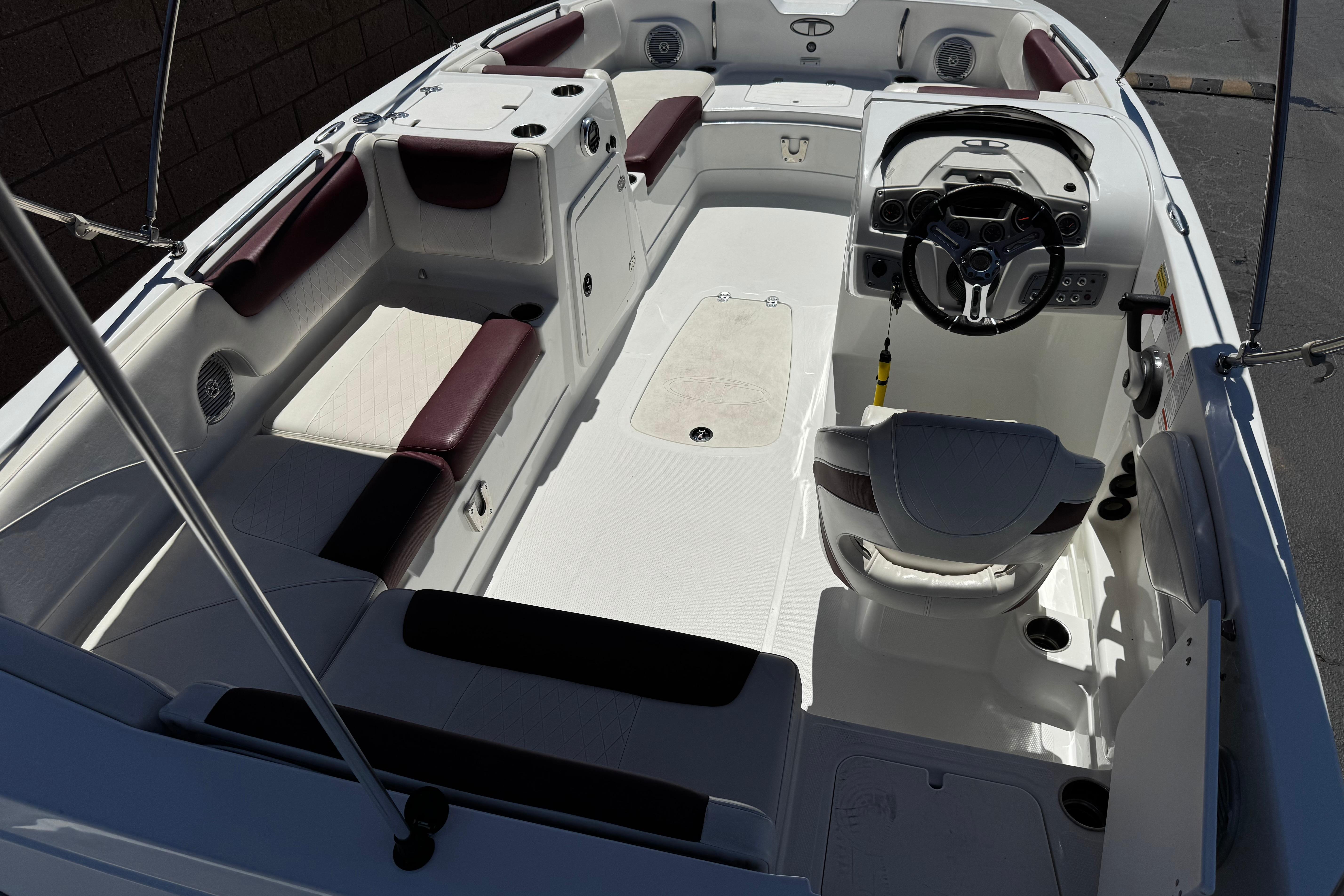 2017 Tahoe 2150 boat interior with white and maroon seating, steering console, and spacious layout.