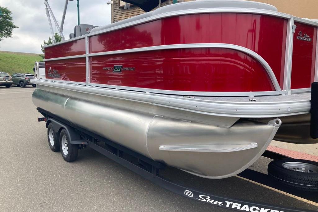 2026 Sun Tracker Party Barge 20 DLX pontoon boat on trailer, red exterior.