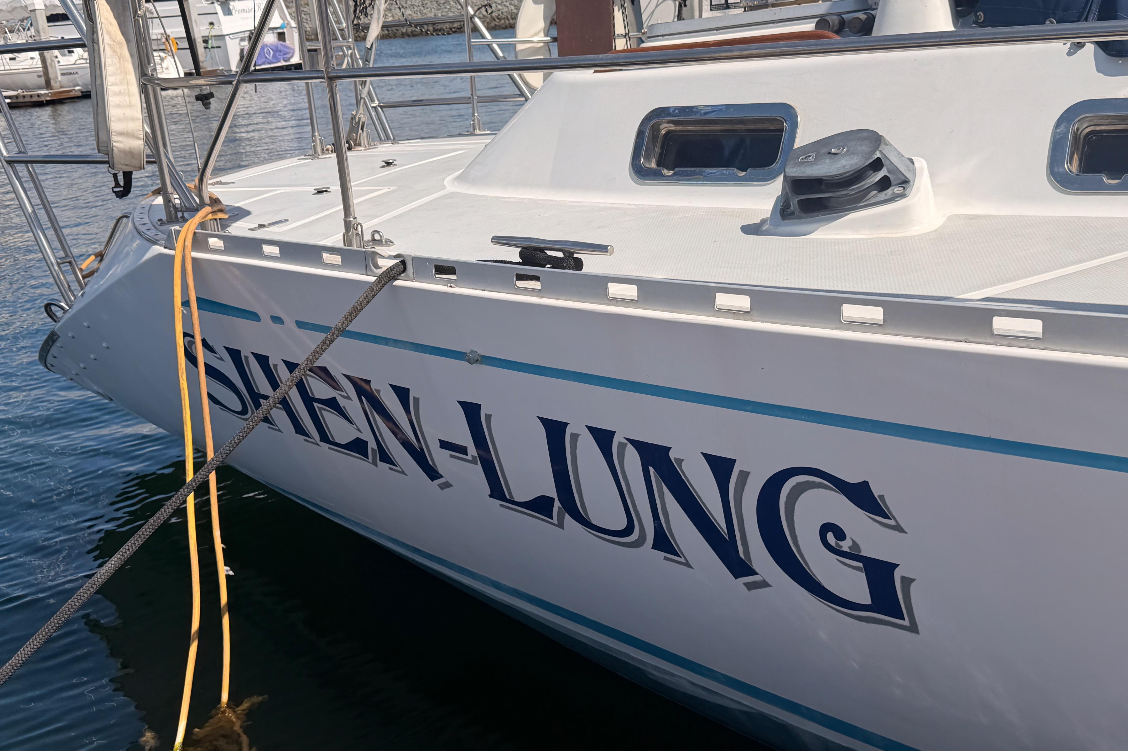 Sailboat "SHEN-LUNG" docked, Hylas 51 model, 1991, in a marina setting.