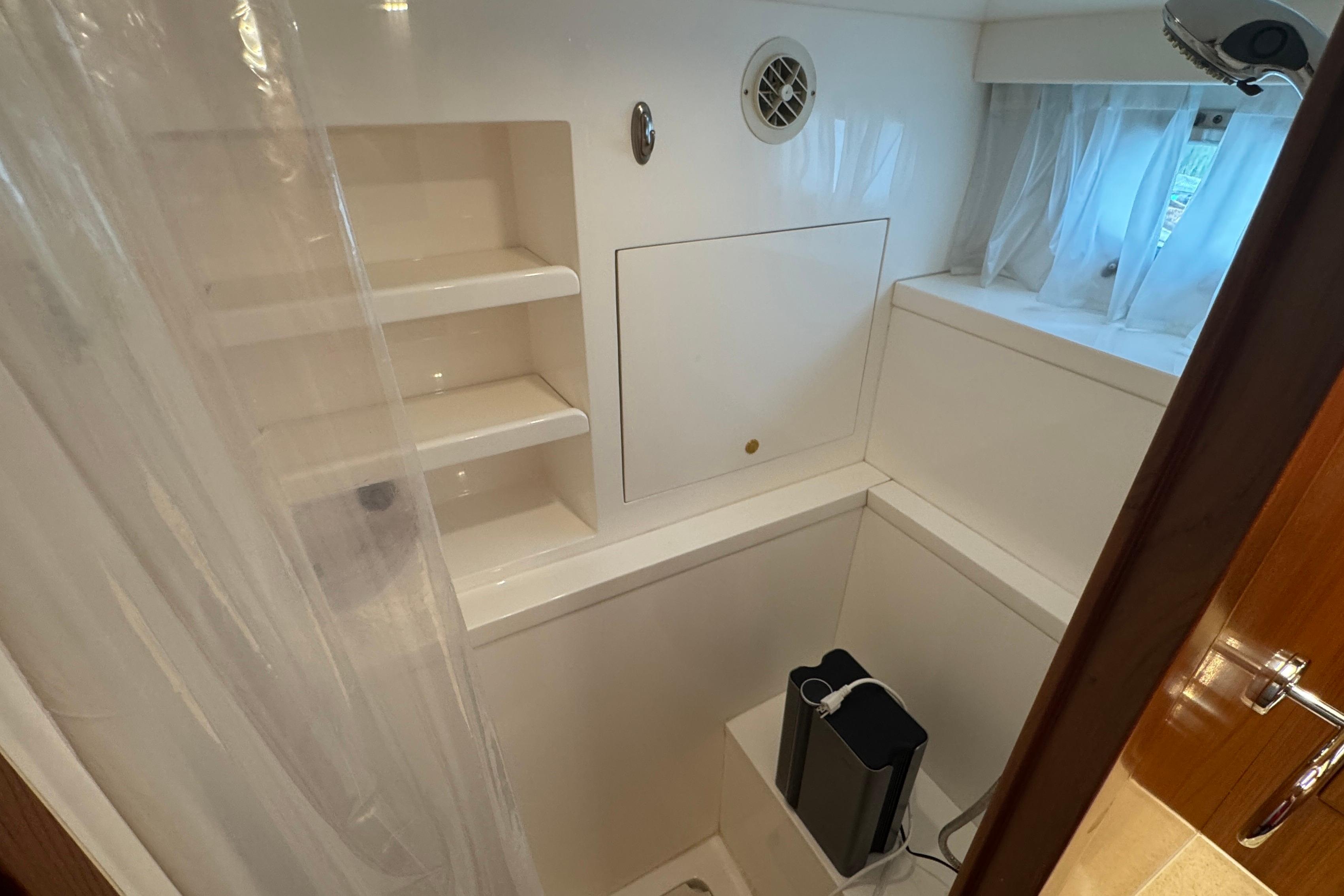 Compact bathroom with shelves and window in 2007 Jefferson Pilothouse 52 SE yacht.