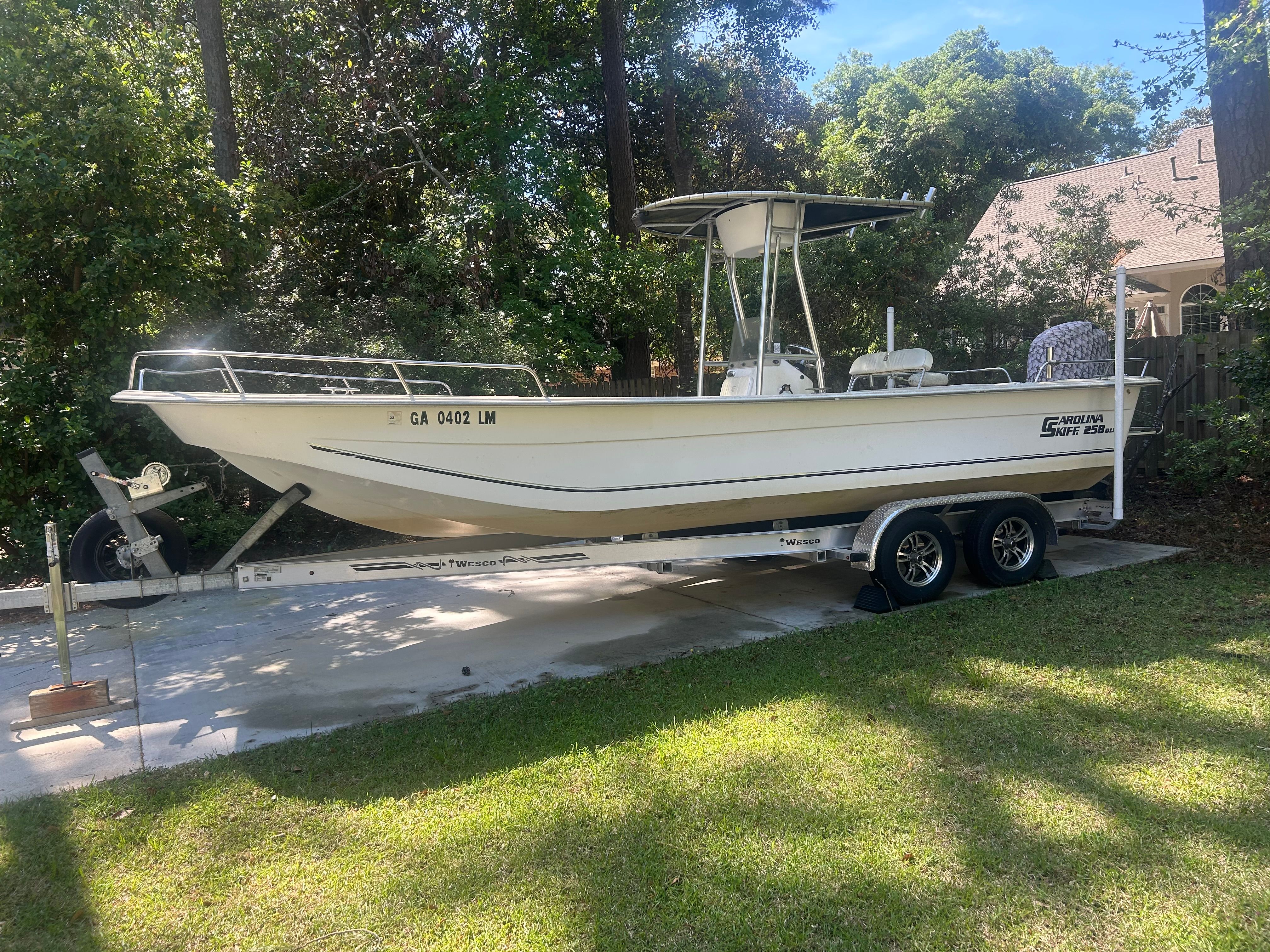 2011 Carolina Skiff 258 DLV boat on trailer in backyard.