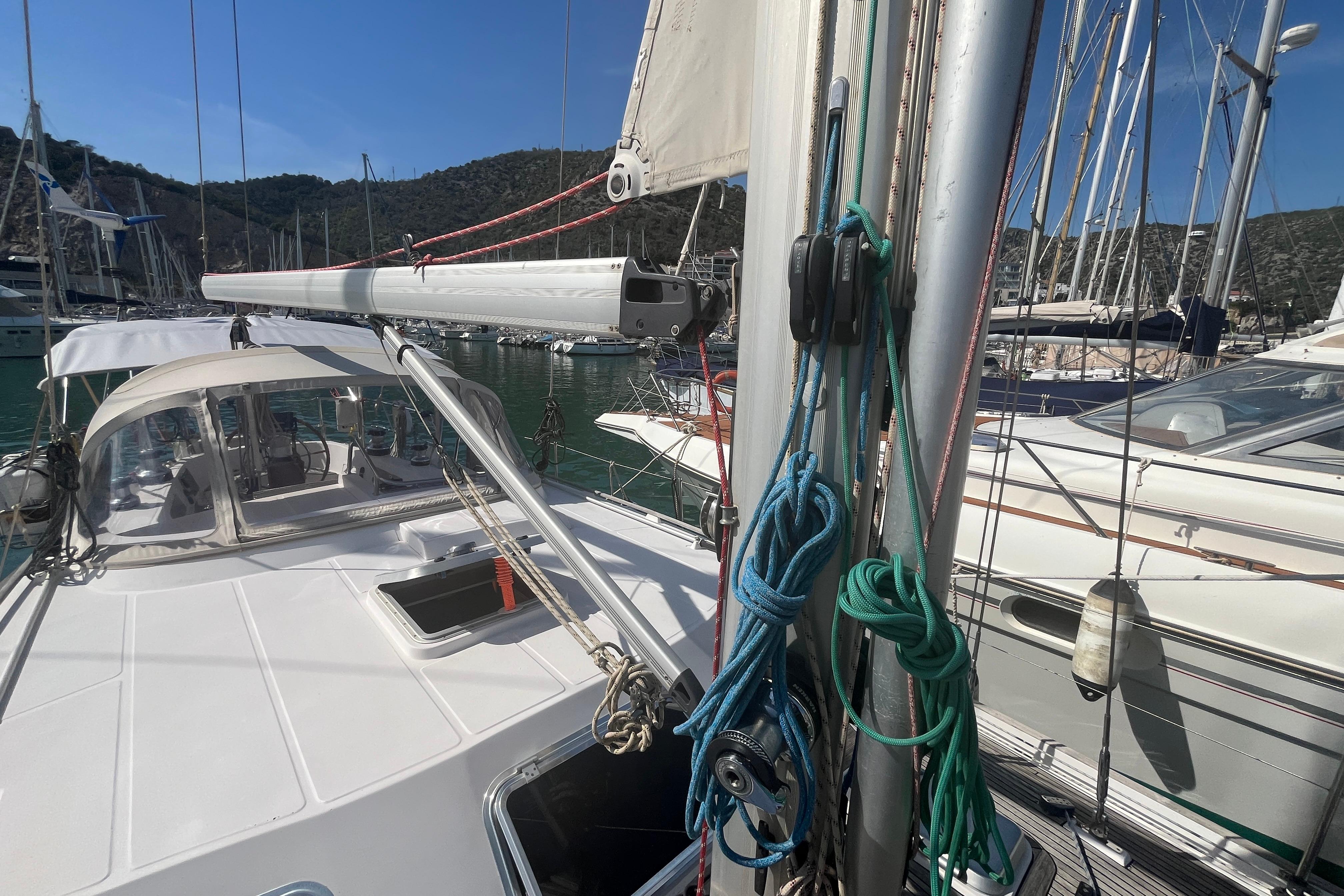 Sailboat Belliure 41, 1995 model, docked in a marina with clear skies.