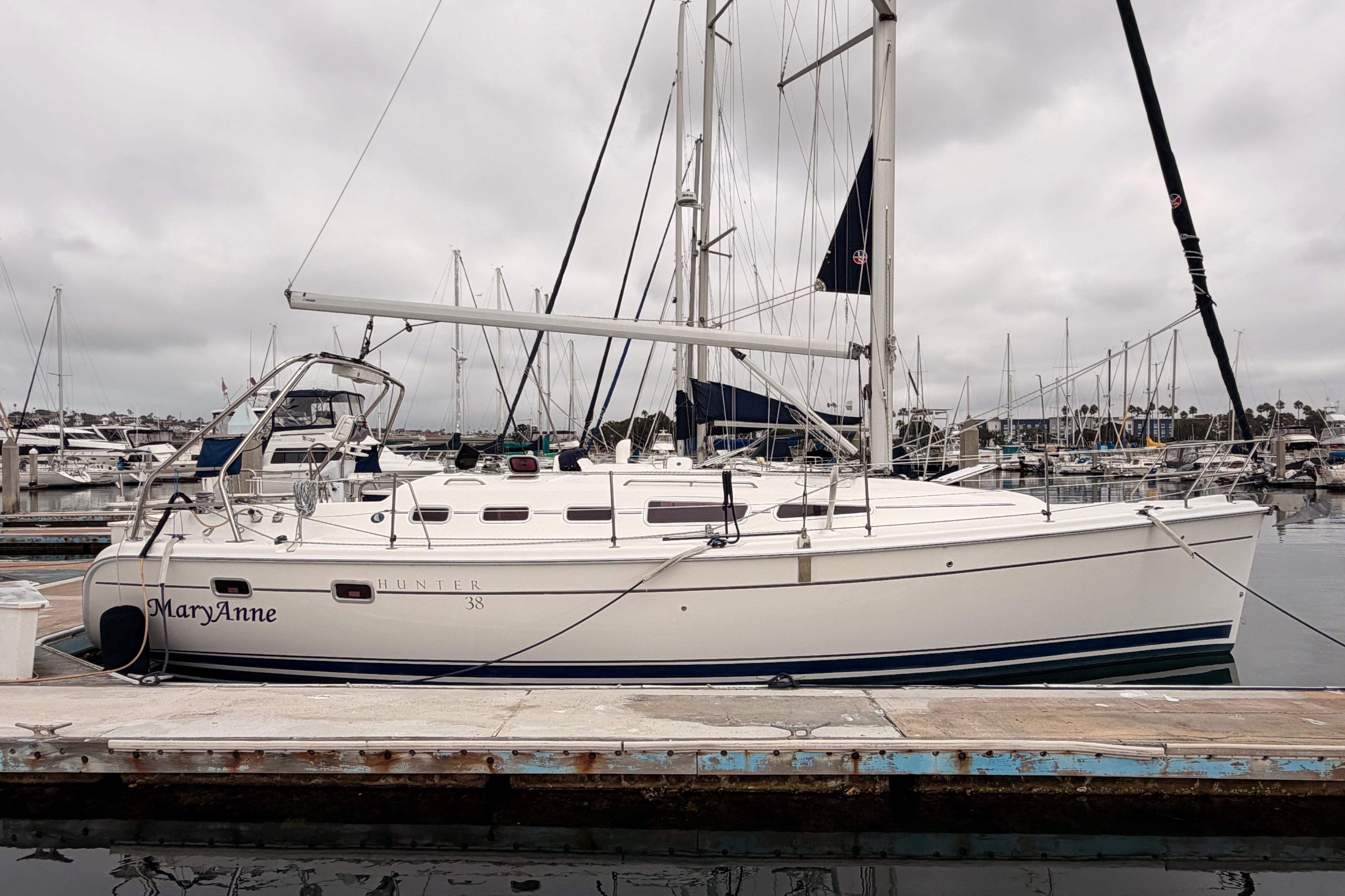 2009 Hunter 38 sailboat docked at marina under cloudy skies.